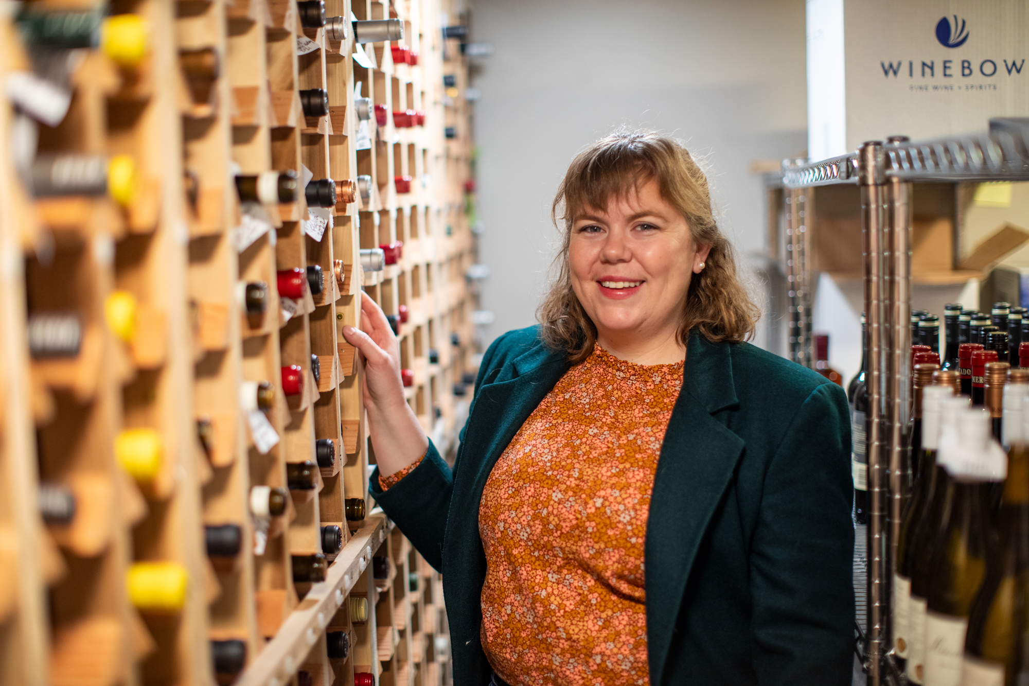 a woman standing near a wine cellar
