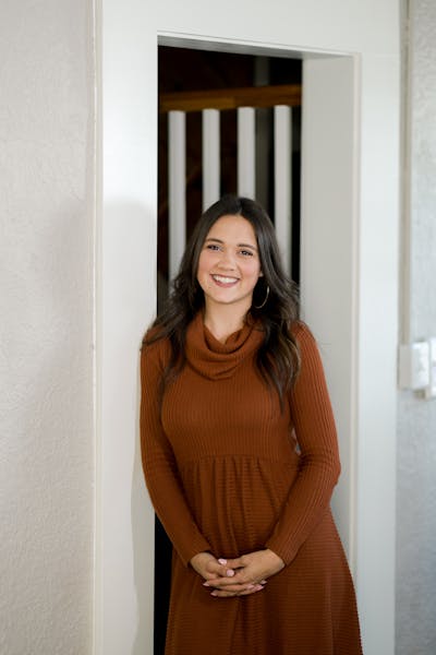 a woman standing in front of a mirror posing for the camera