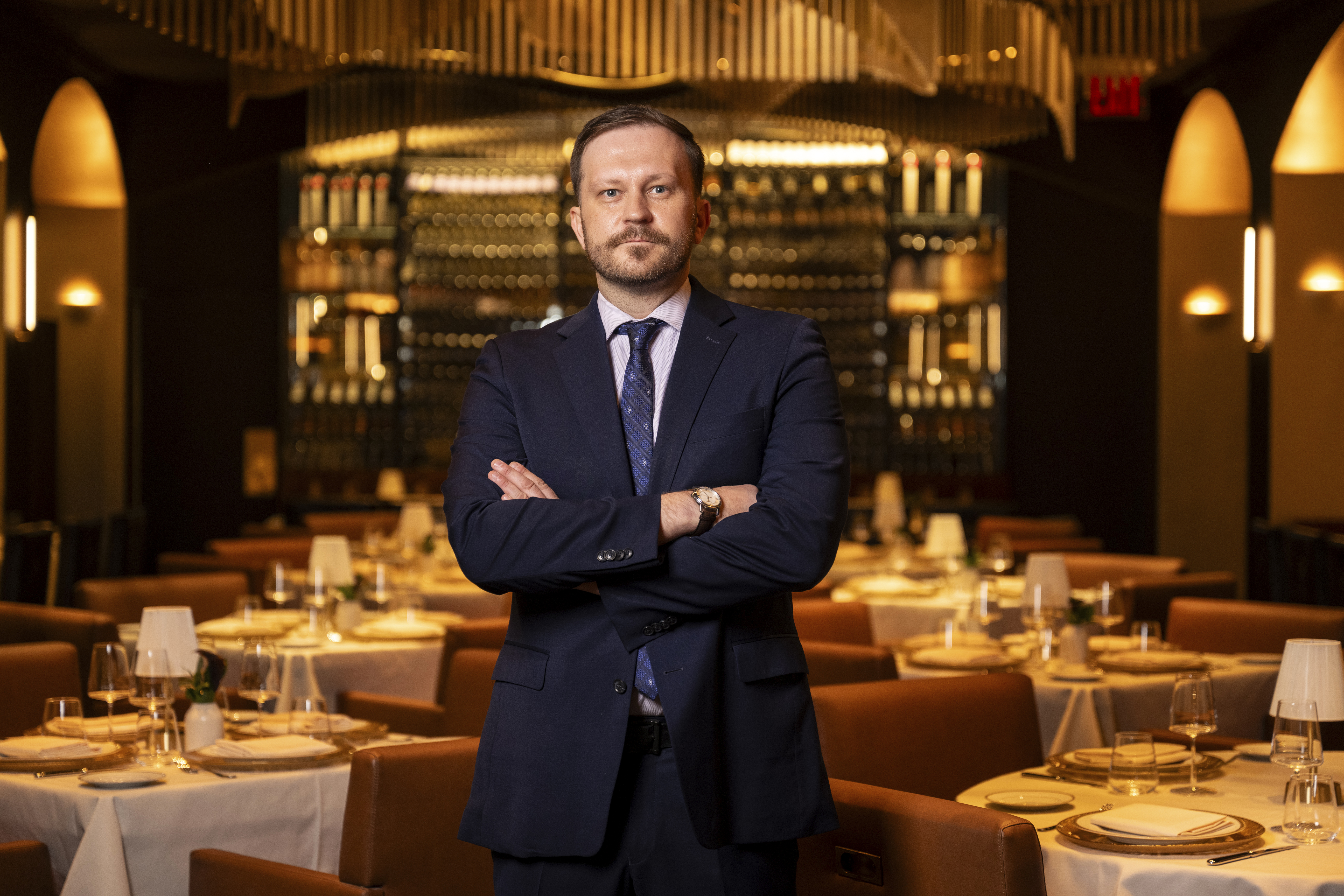 a man in a suit standing in front of a table