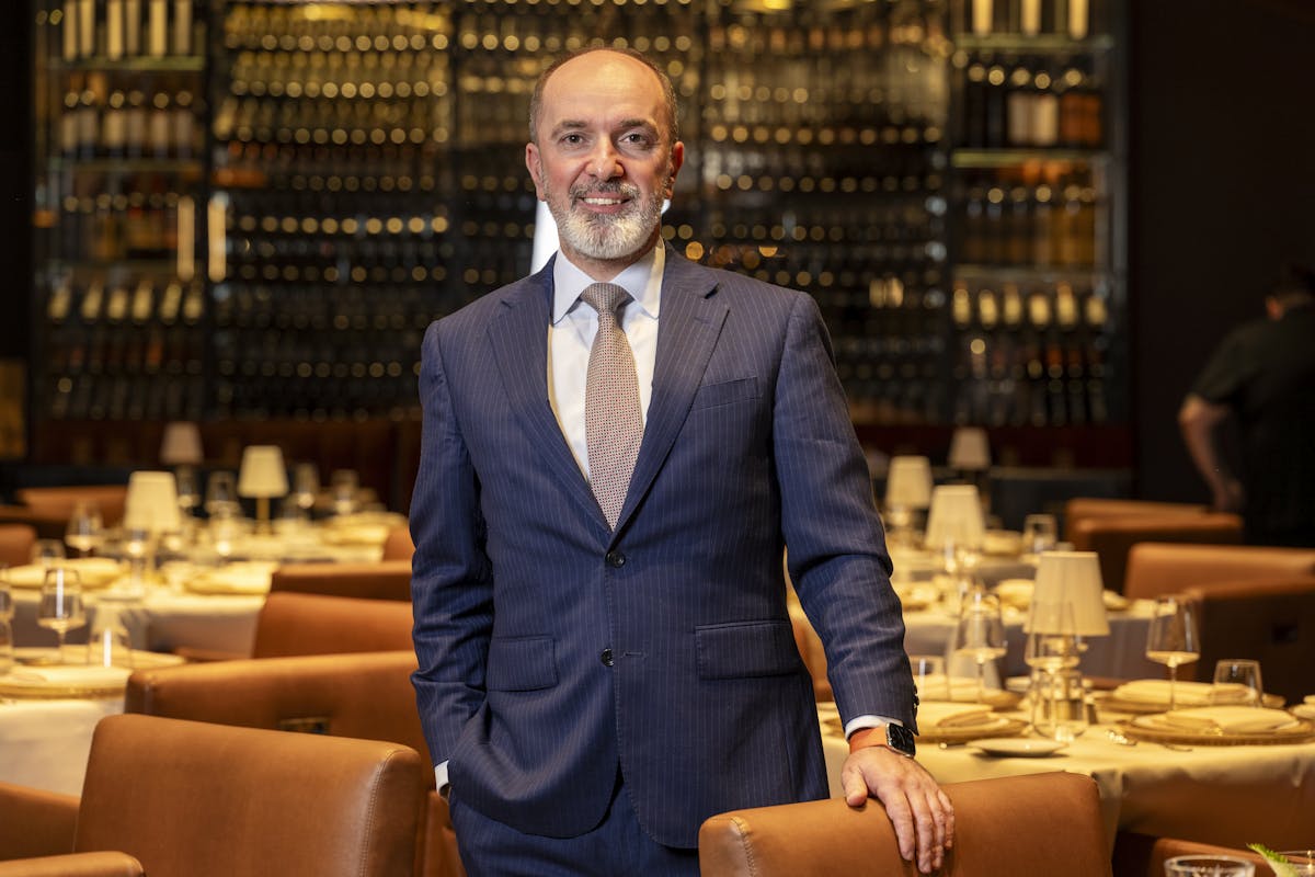 a man in a suit standing in front of a table
