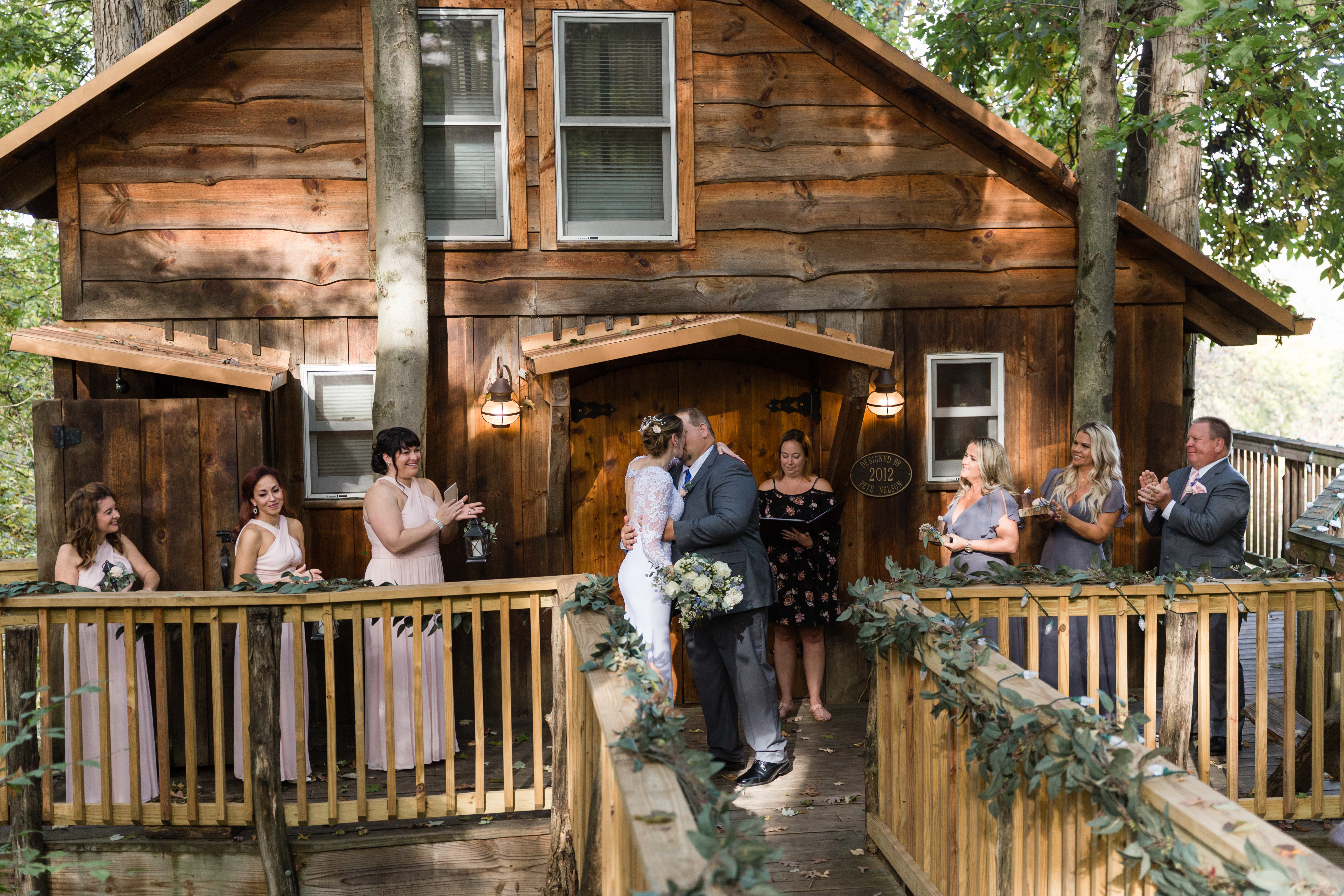 a group of people standing on top of a wooden fence