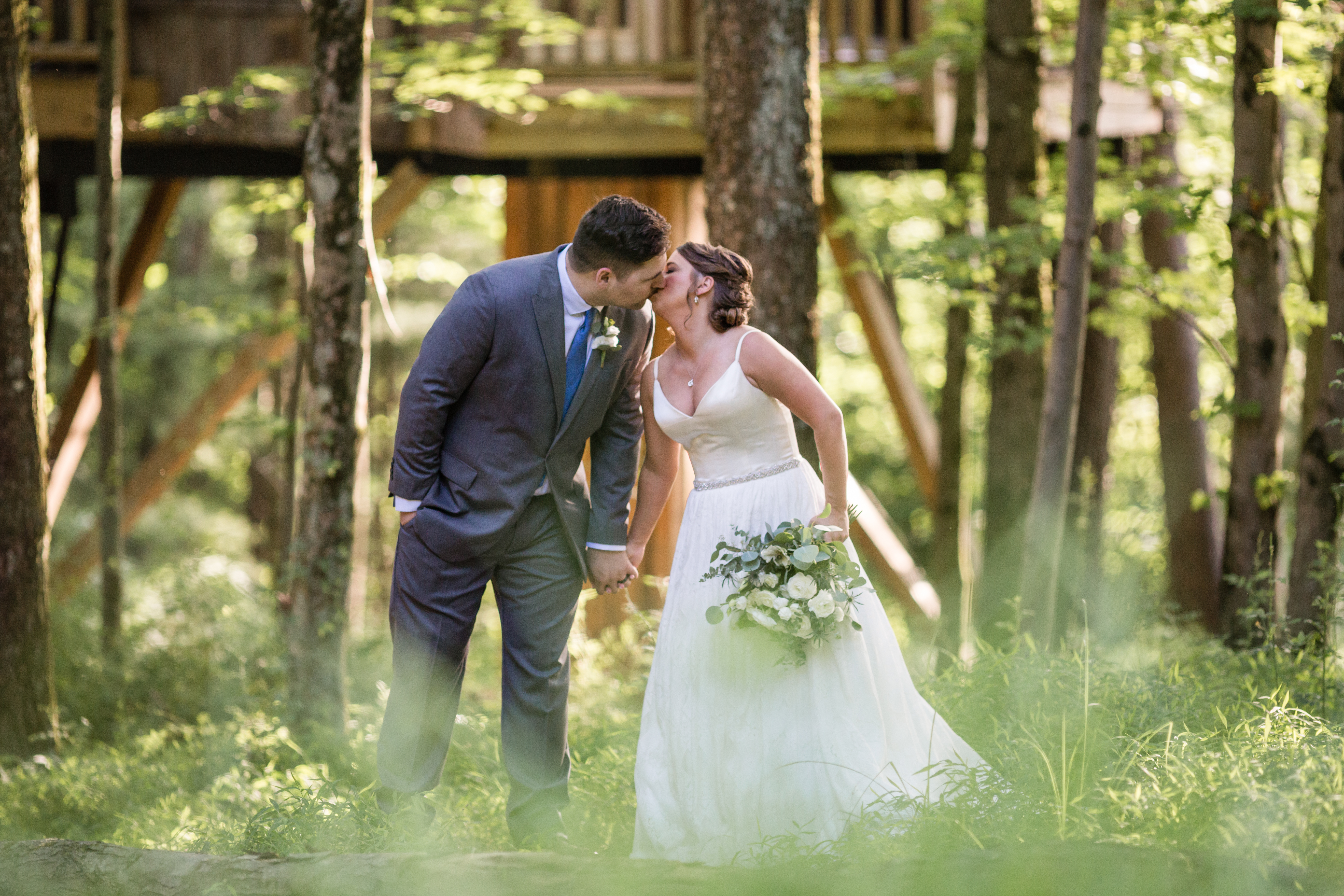 a man and woman kissing in the woods