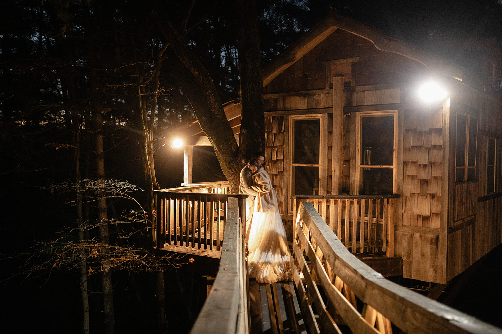 a man and woman hugging on a deck of a house