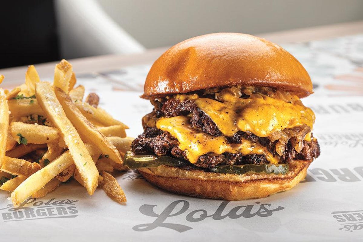 a close up of a double patty double cheese smash burger on a plate