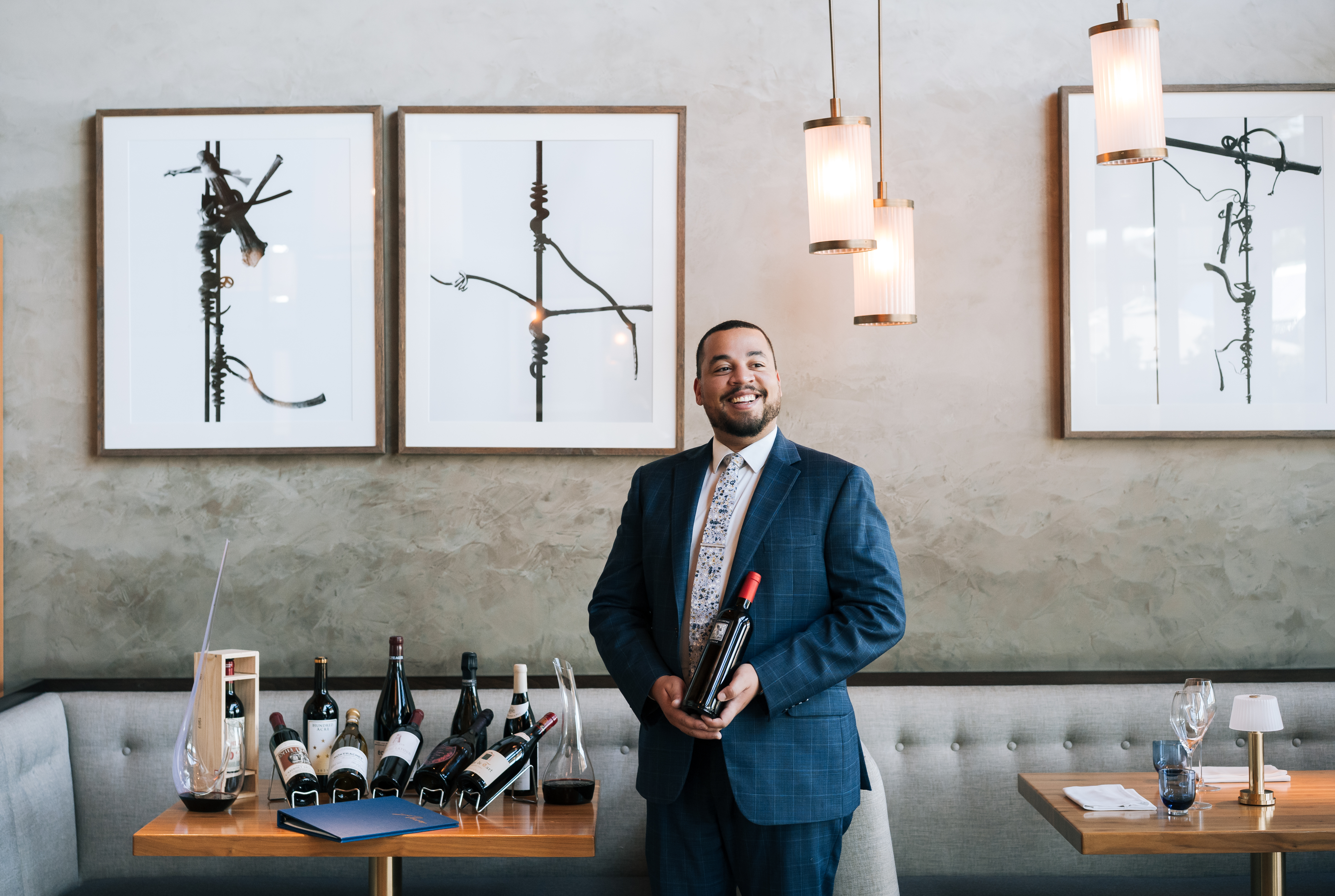 a man in a suit holding a bottle of wine
