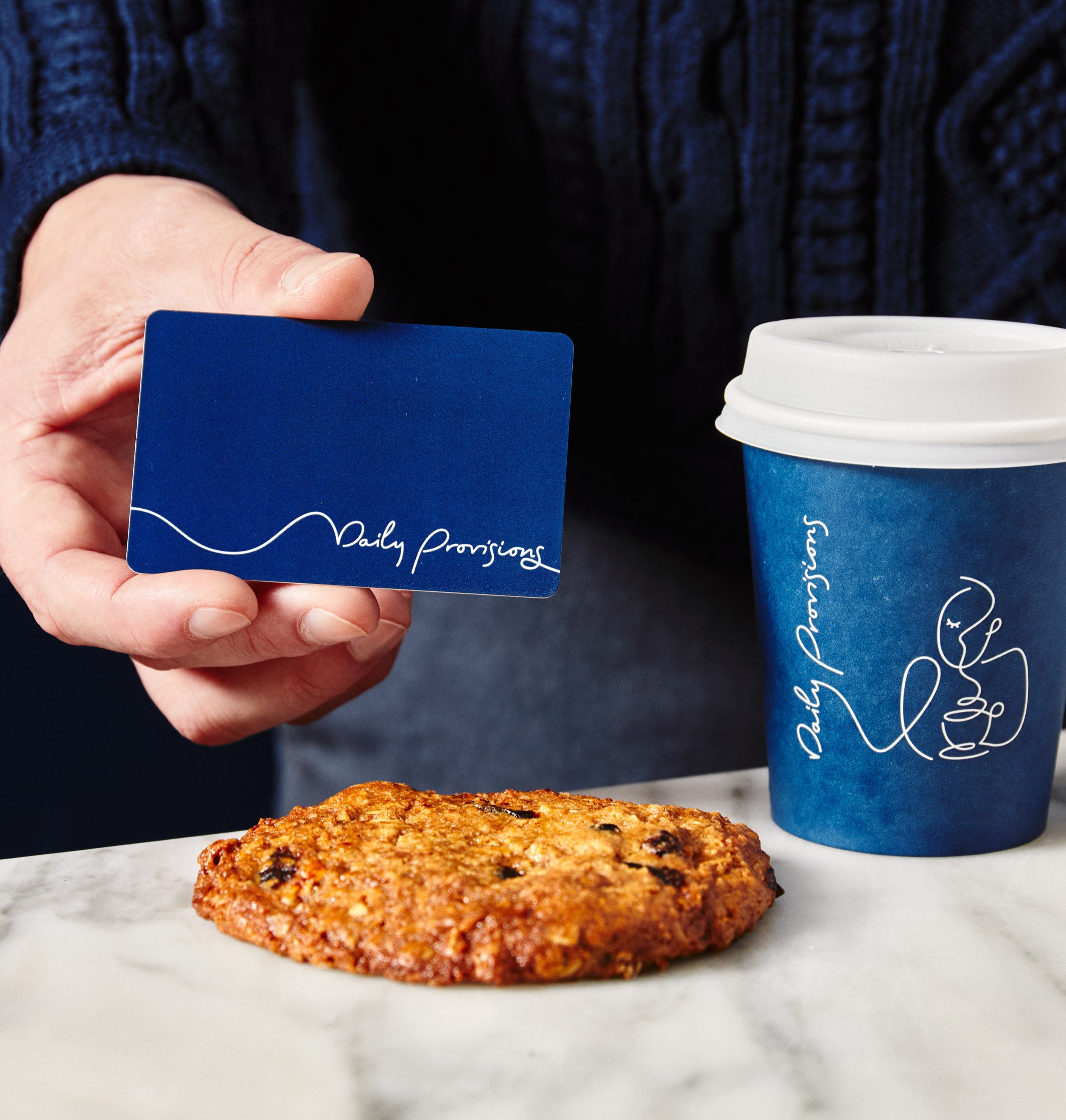 a person sitting at a table with food and a cup of coffee