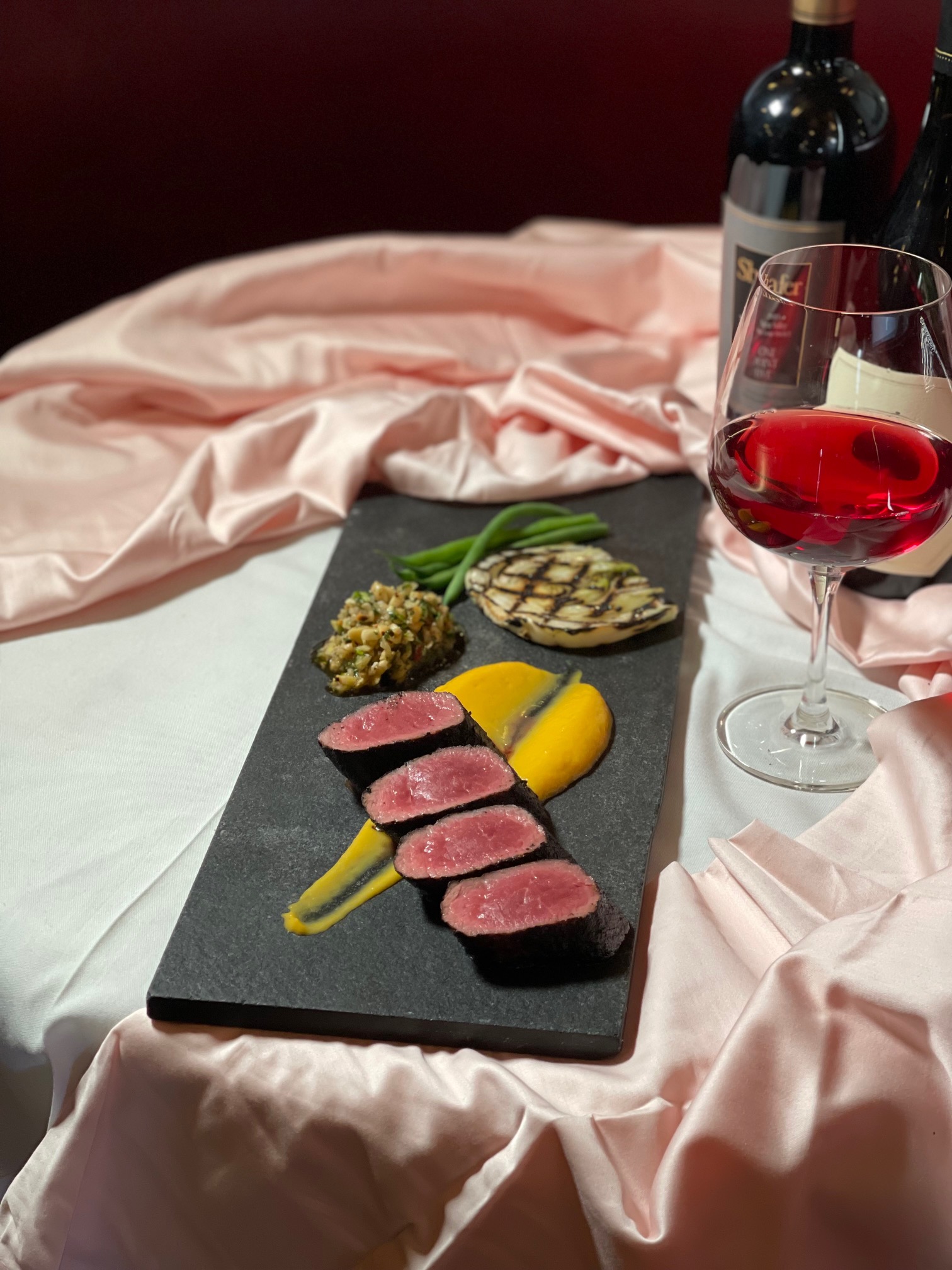 a bottle of wine sitting on top of a bed
