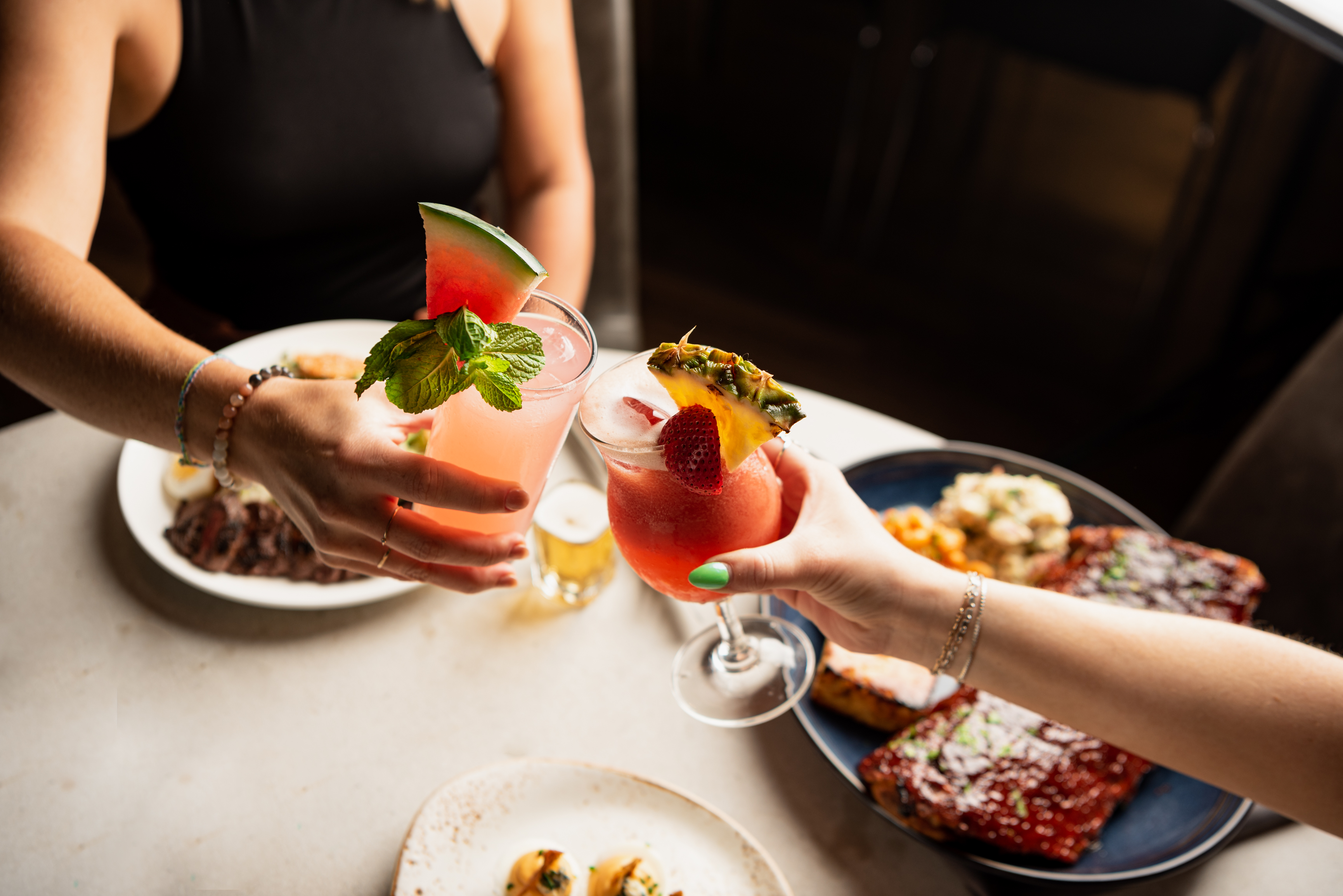 a woman holding a plate of food on a table