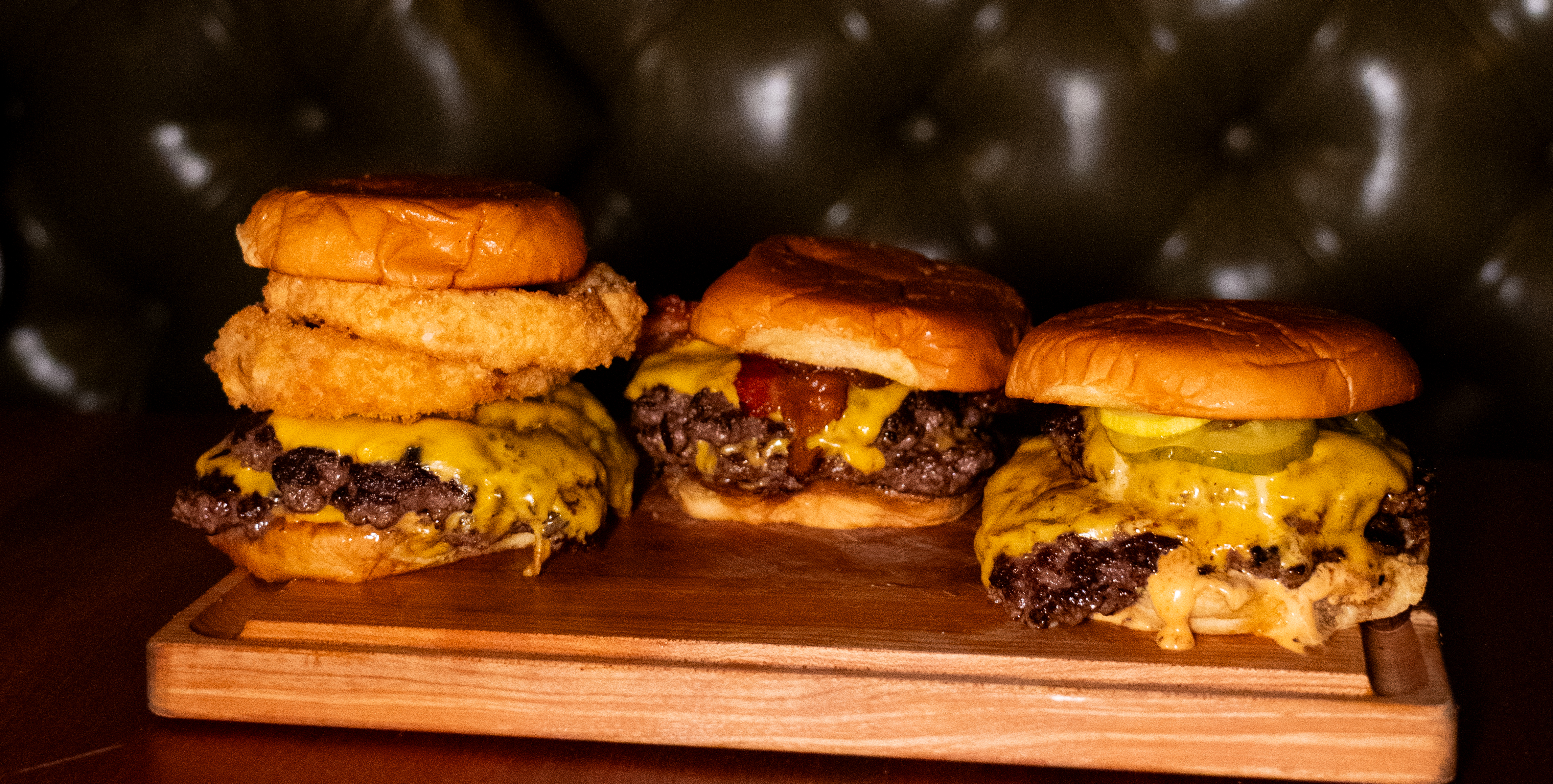 a group of burgers on a wooden board