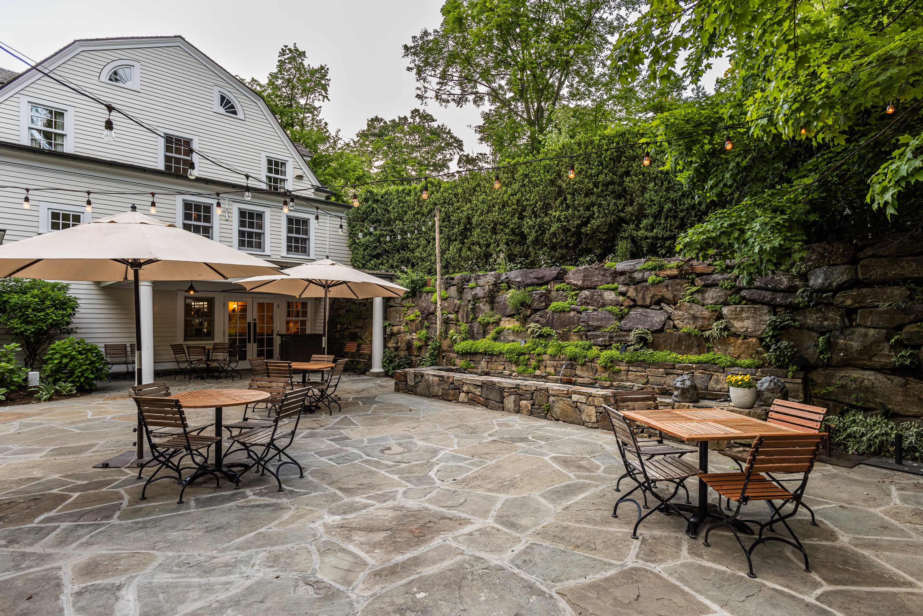 a group of lawn chairs sitting on a bench in front of a house