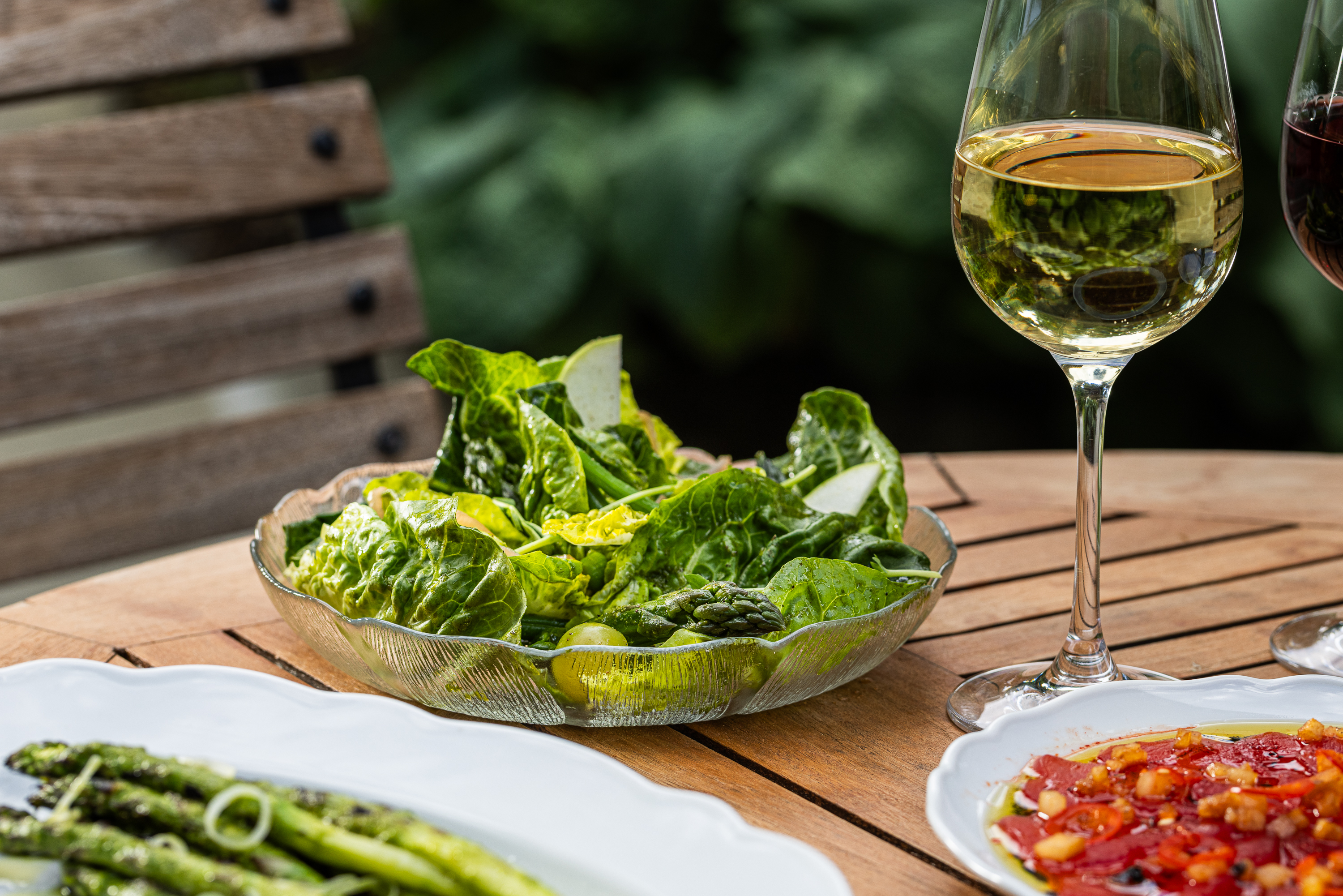 a plate of food and glasses of wine sitting on top of a table