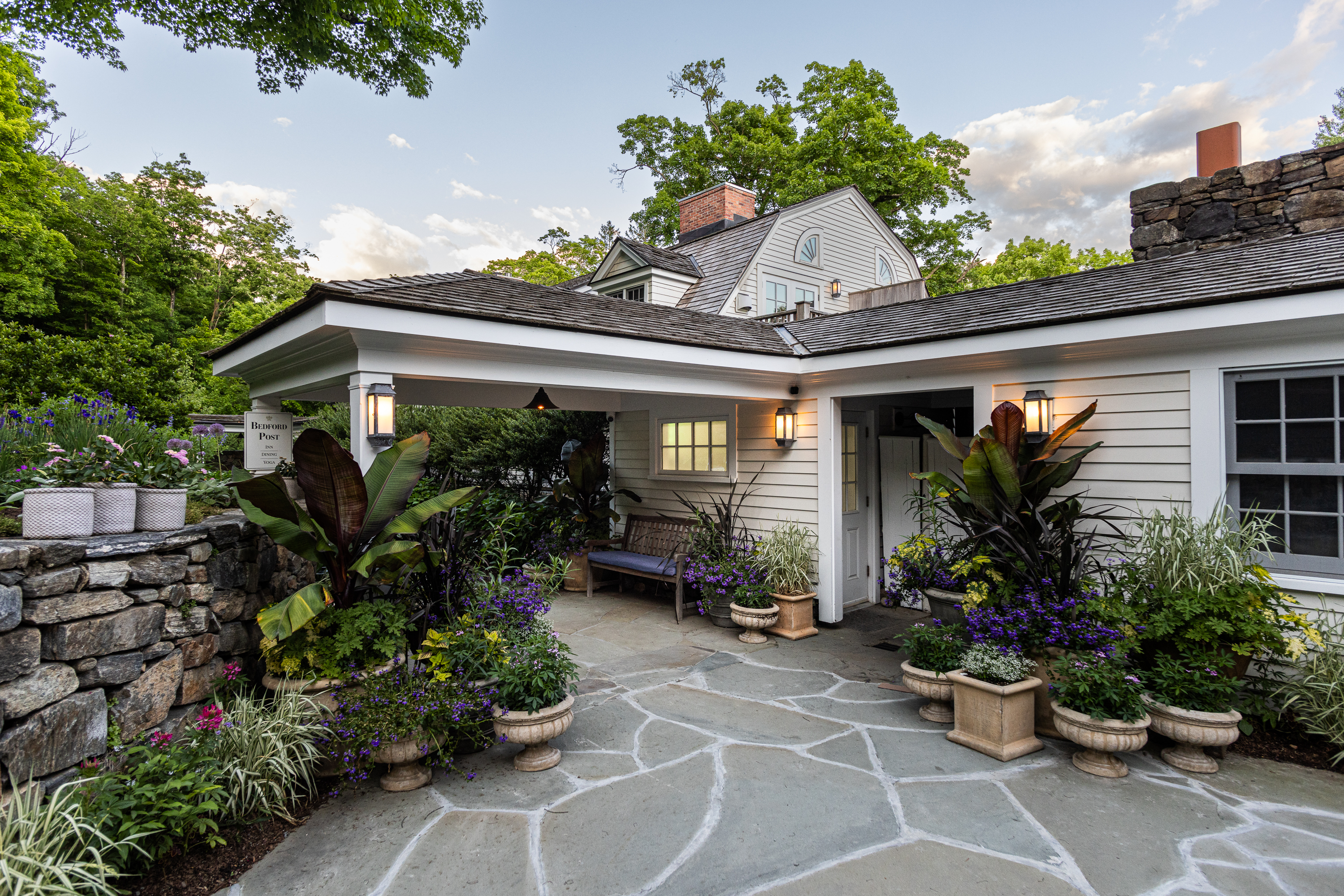 a stone building that has a garden in front of a house