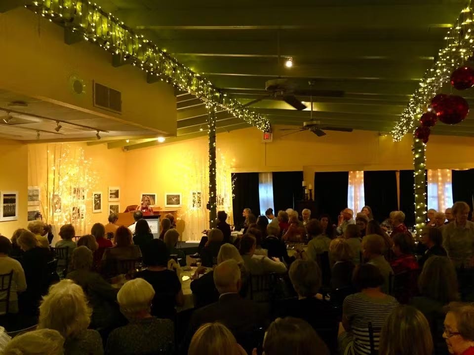 a group of people watching a band on stage in front of a crowd