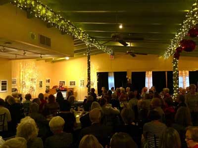 a group of people watching a band on stage in front of a crowd