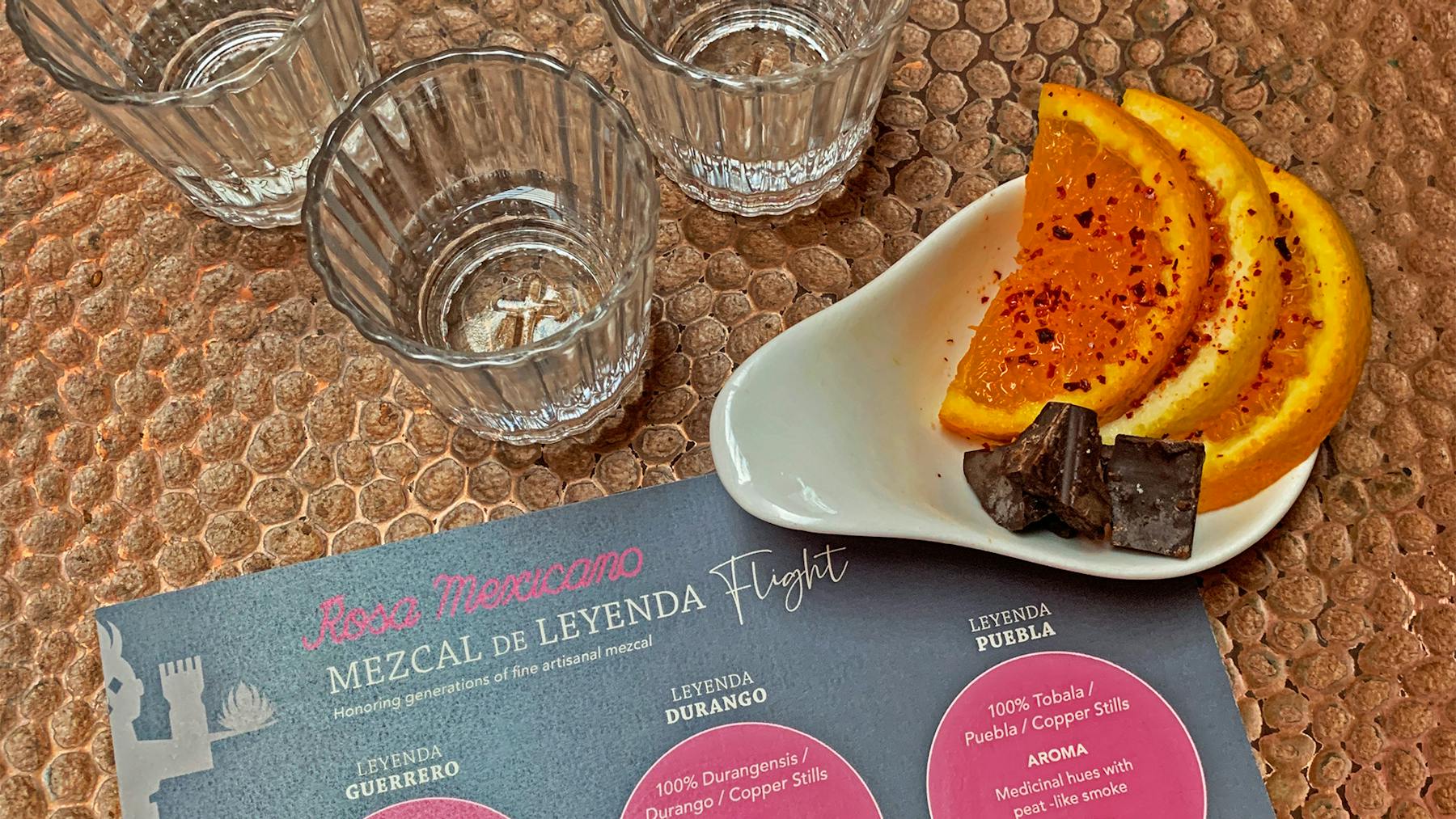 Mezcal flight with orange slices and chocolate