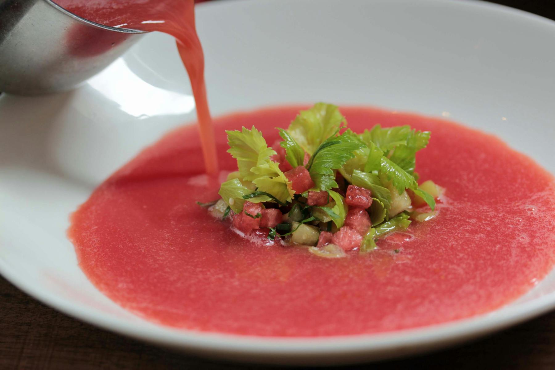 a red and white bowl of food on a plate