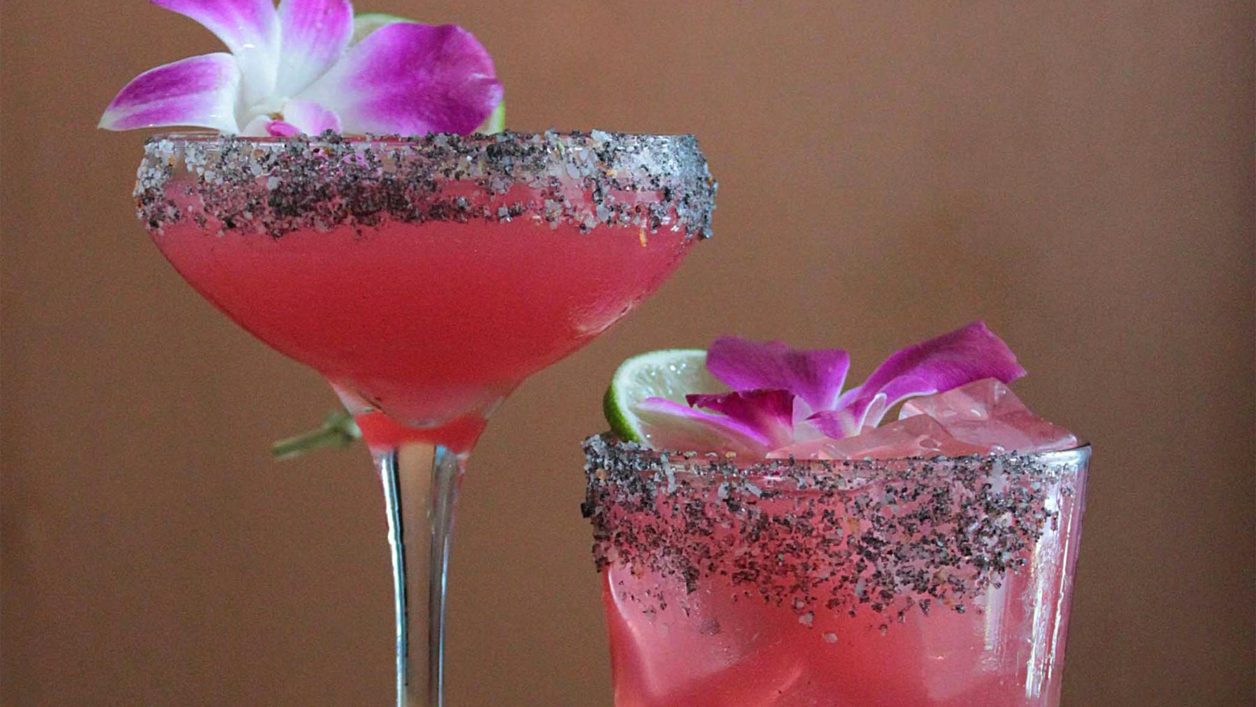 two glasses of Margaritas with a flower and lime on top