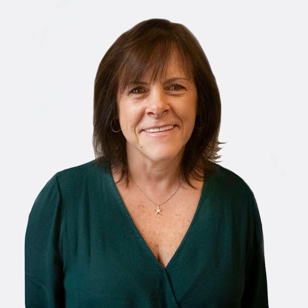 a woman wearing a blue shirt and smiling at the camera