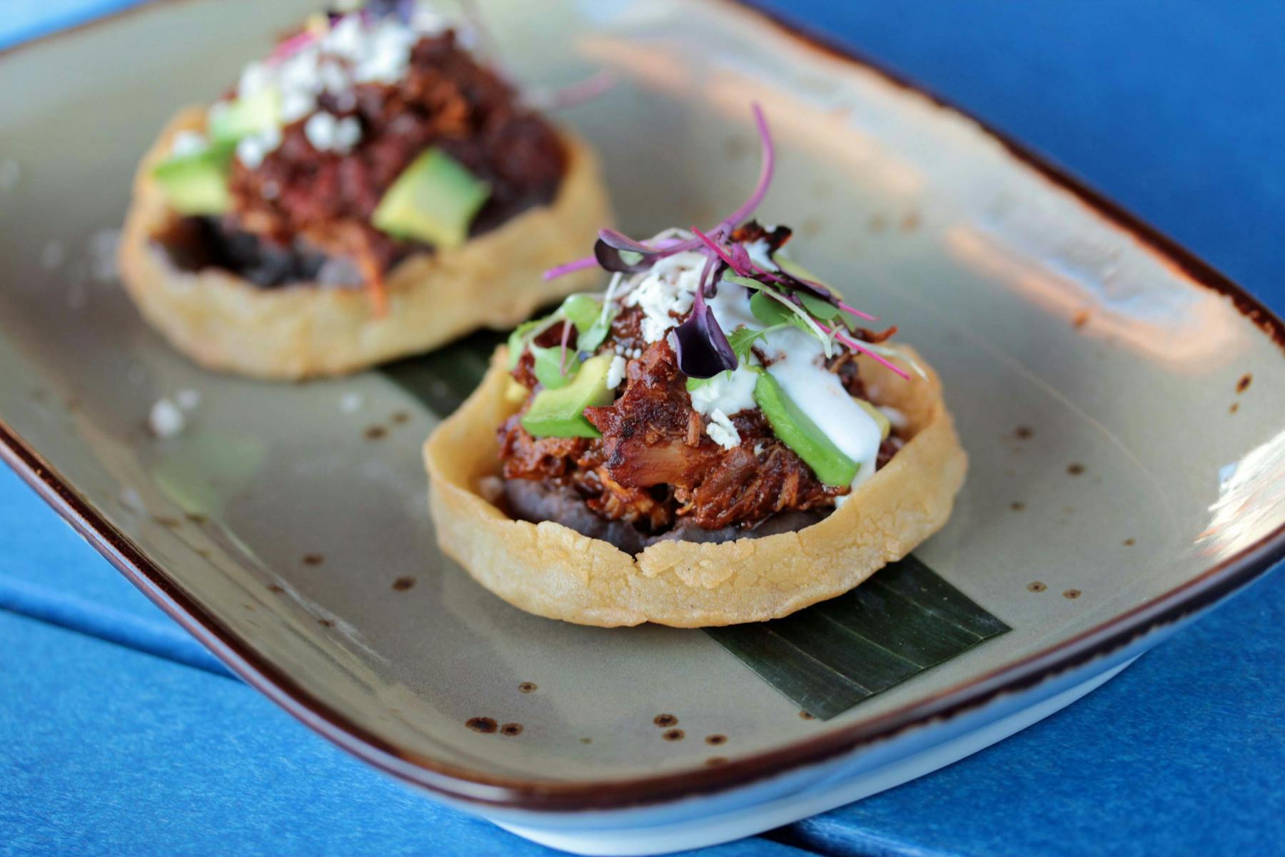 a piece of masa cake with chicken and avocado on a plate