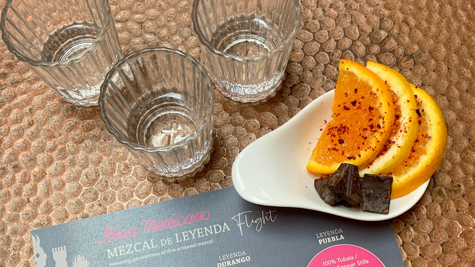 3 small glasses of our Mezcal flights with orange slices and chocolate