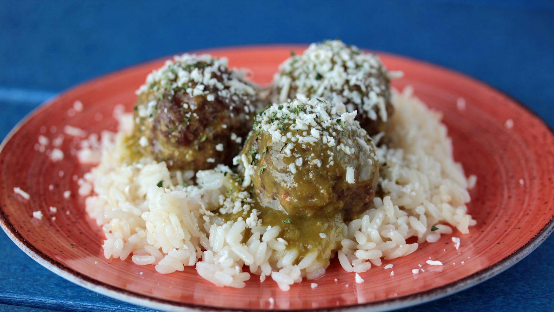 a plate of meatballs on top of rice