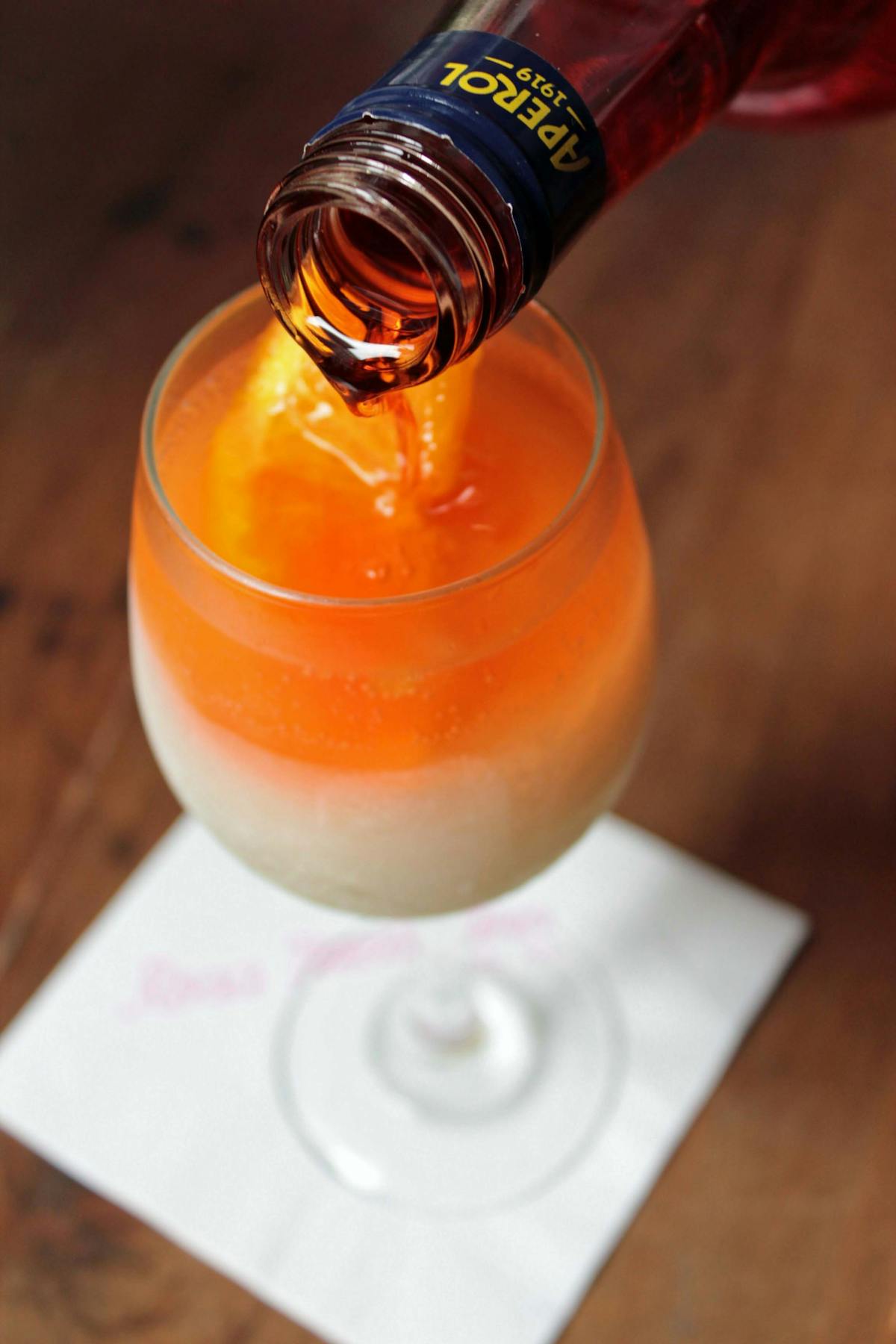 a glass of orange juice on a wooden table