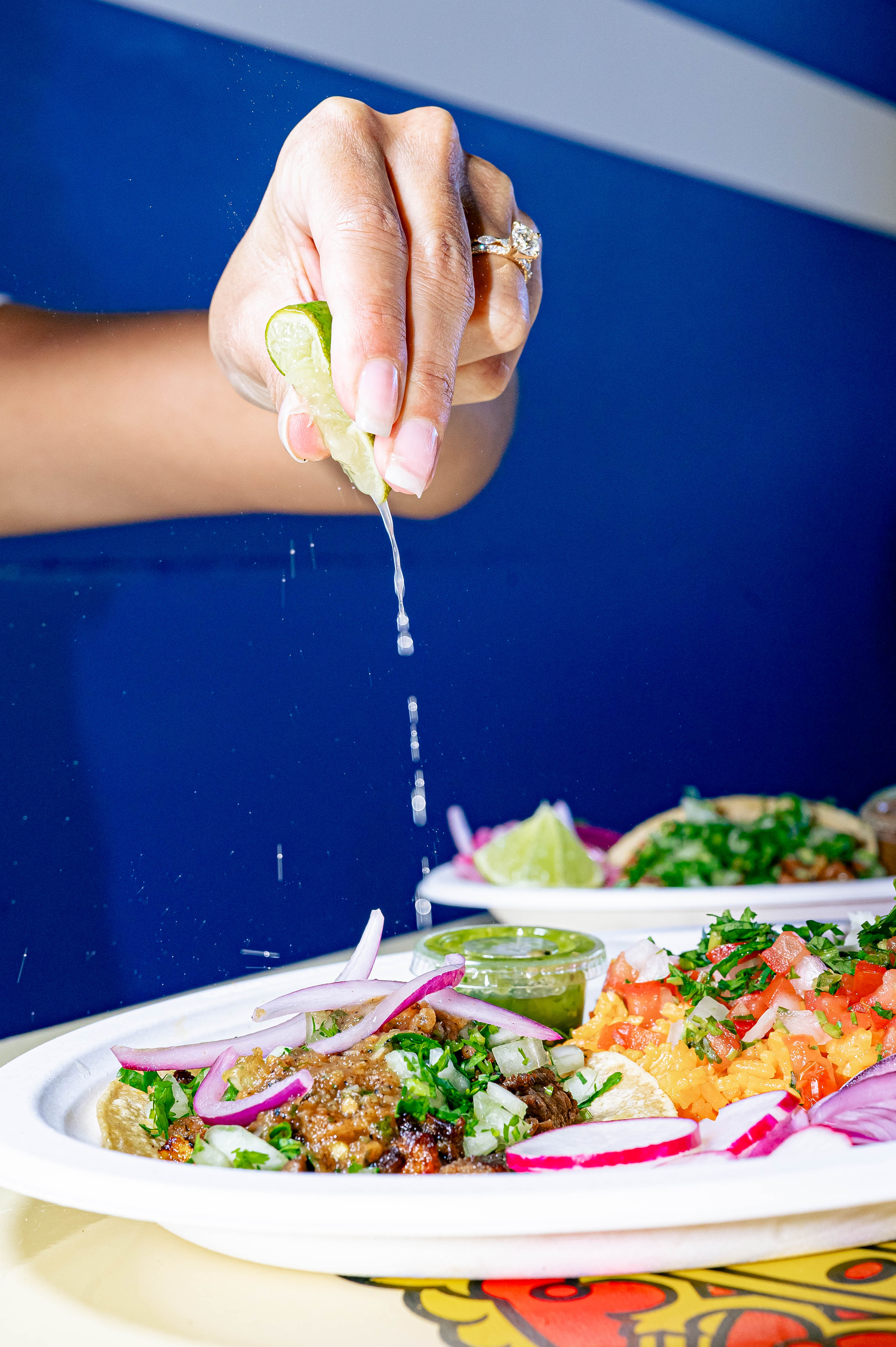a woman sitting at a table with a plate of food