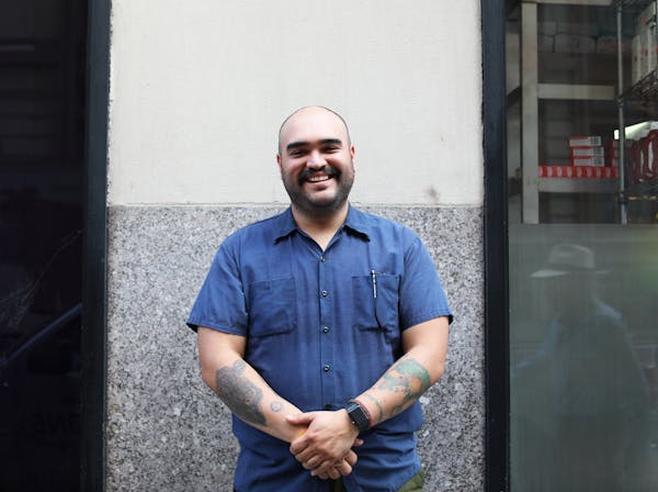 a man in a blue shirt standing in front of a building