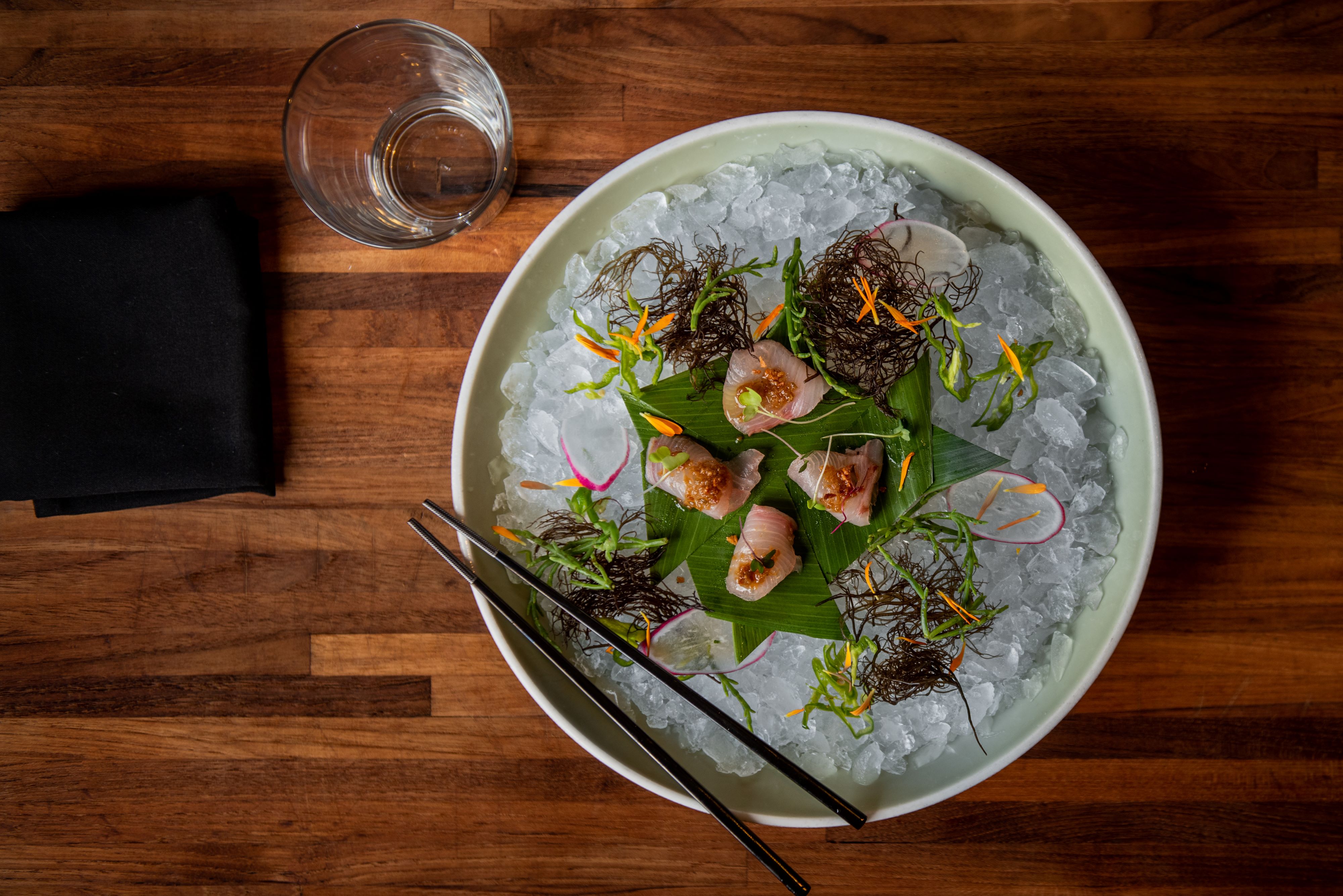 a bowl of food on a plate on a wooden table