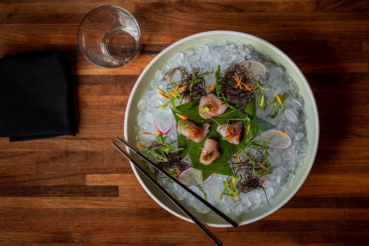 a bowl of food on a plate on a wooden table