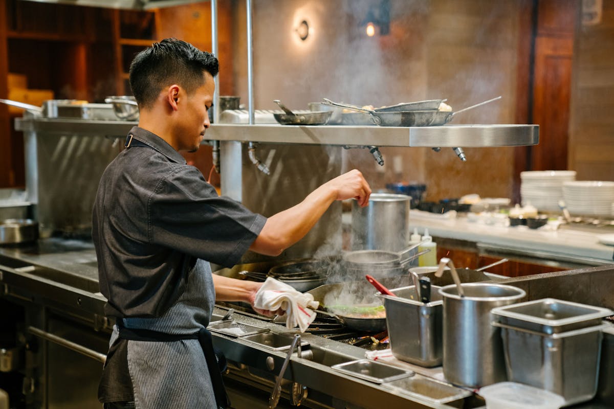 a man cooking in a kitchen preparing food
