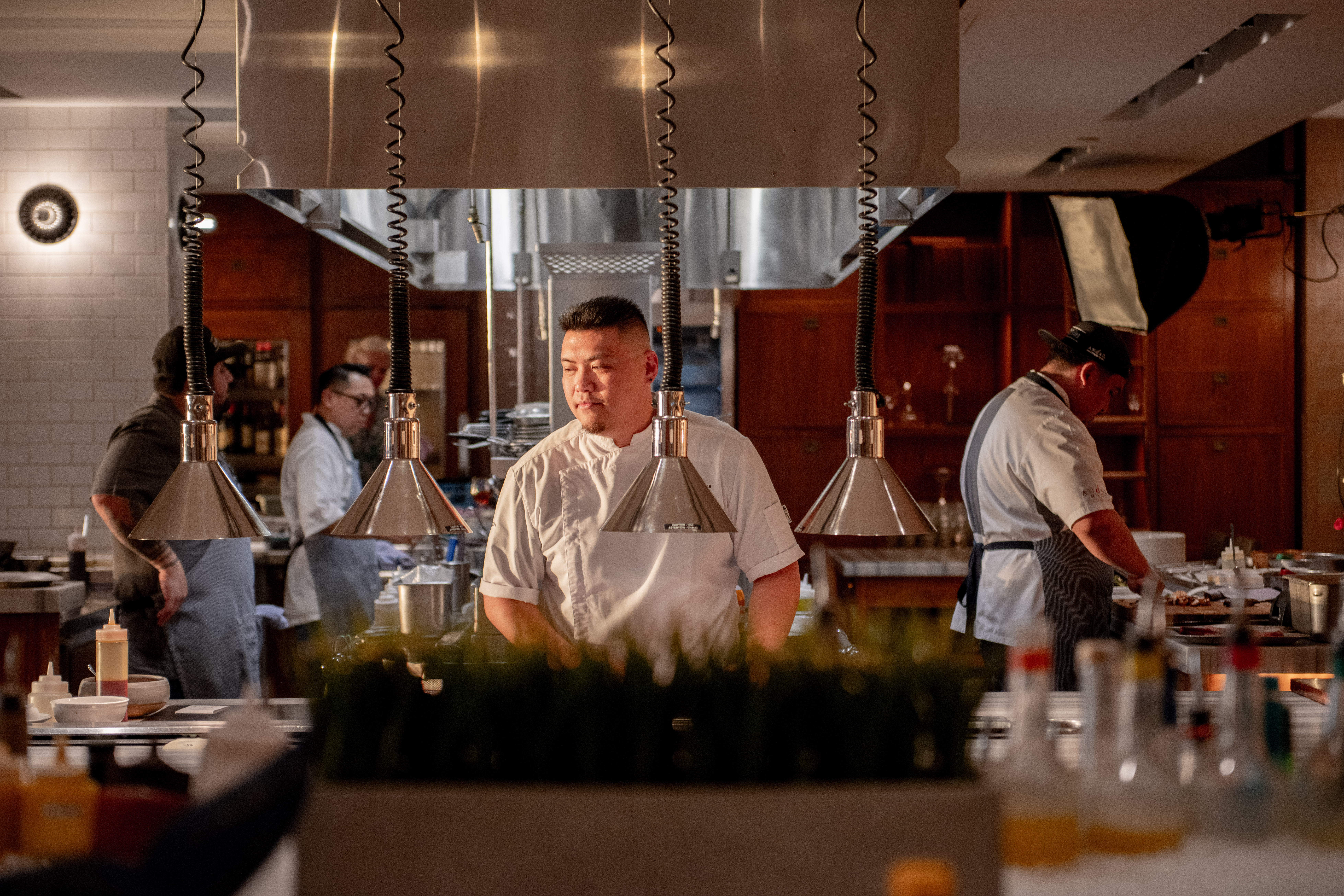 a chef standing in the kitchen looking over the food
