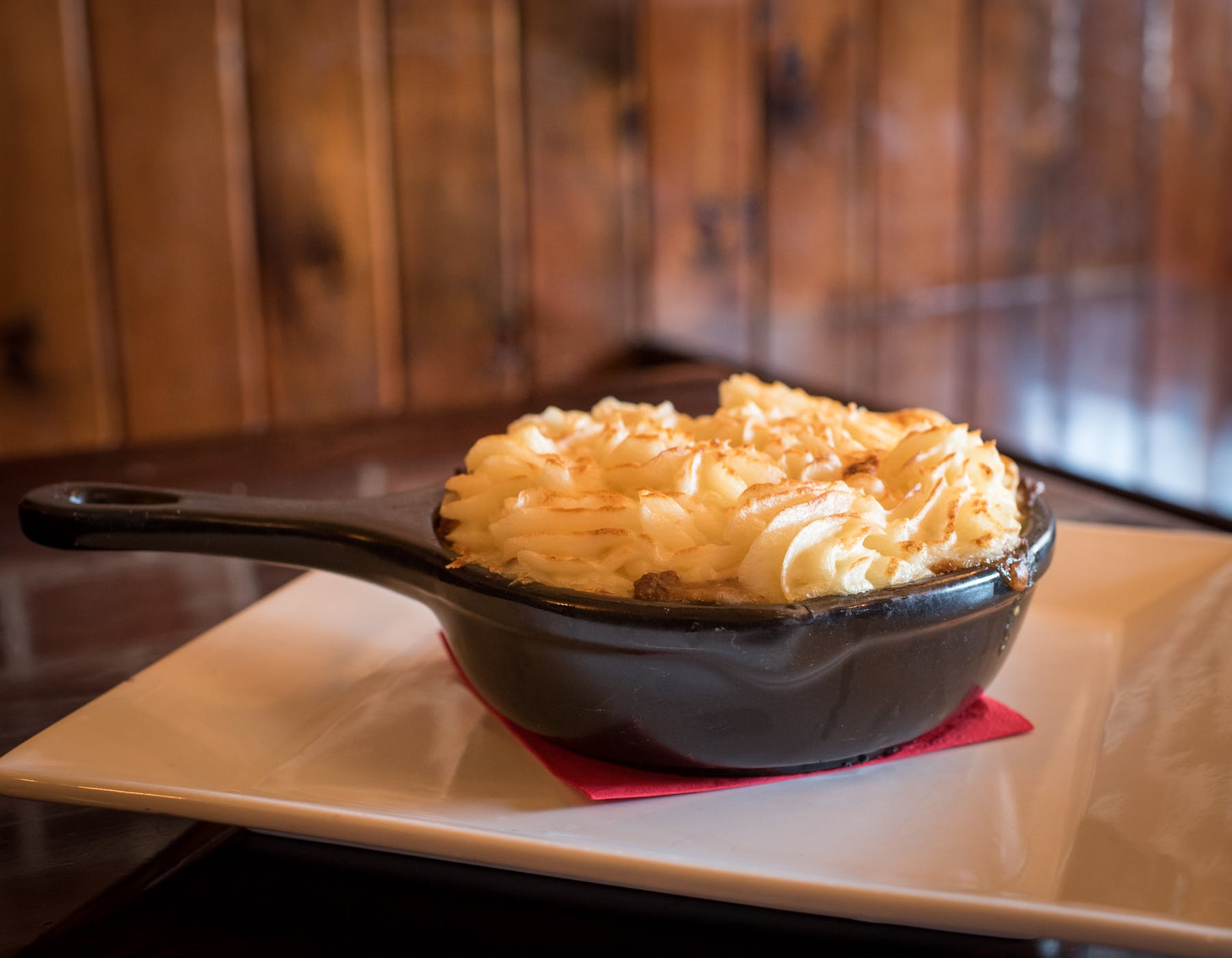 a bowl of food sitting on top of a wooden table