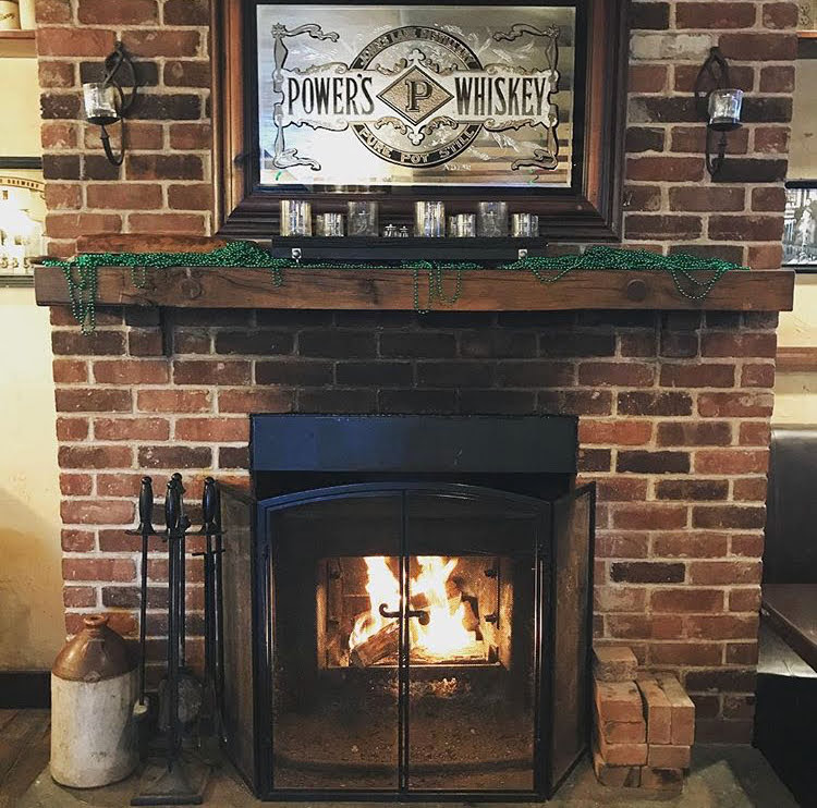 a fire place sitting in front of a brick wall