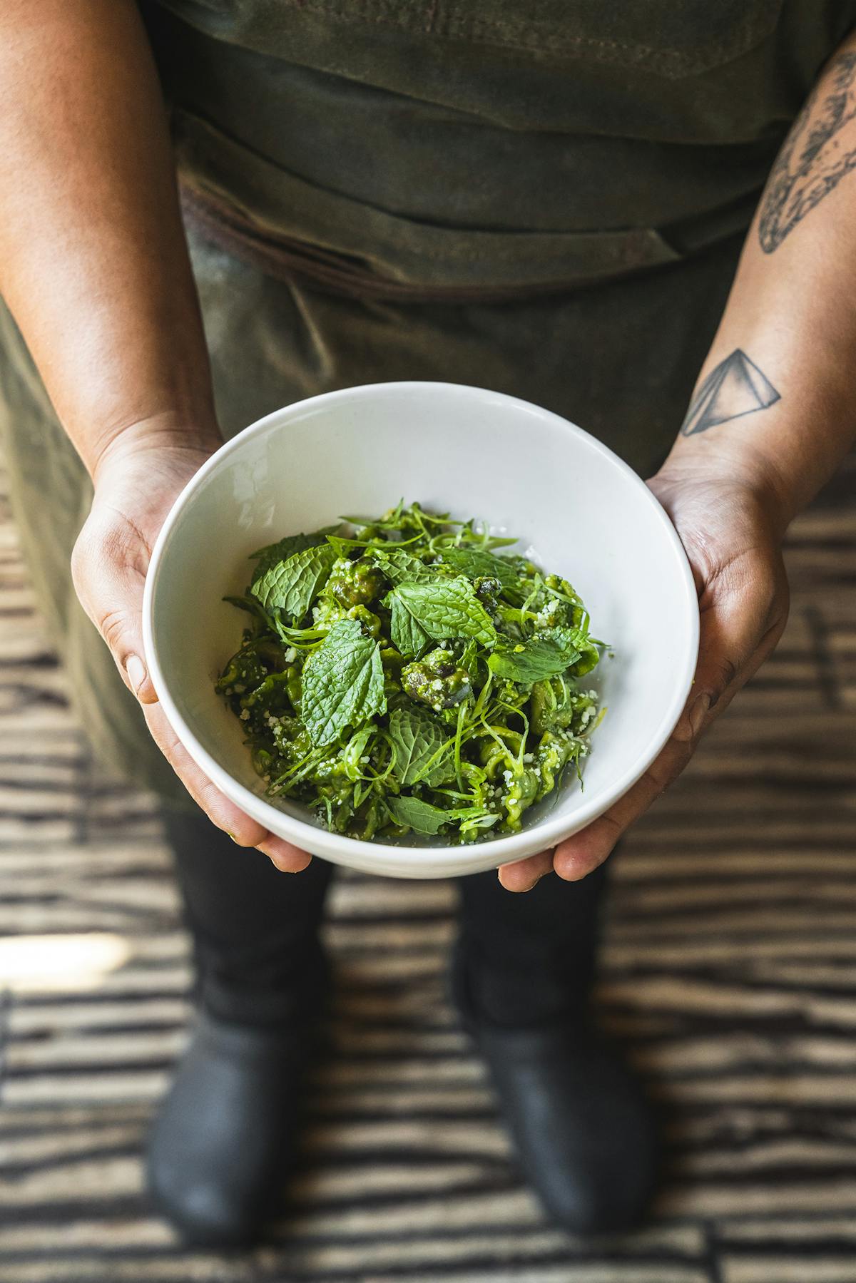 a person holding a bowl of broccoli