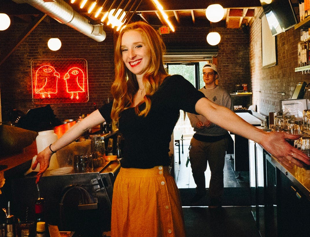woman smiling behind bar