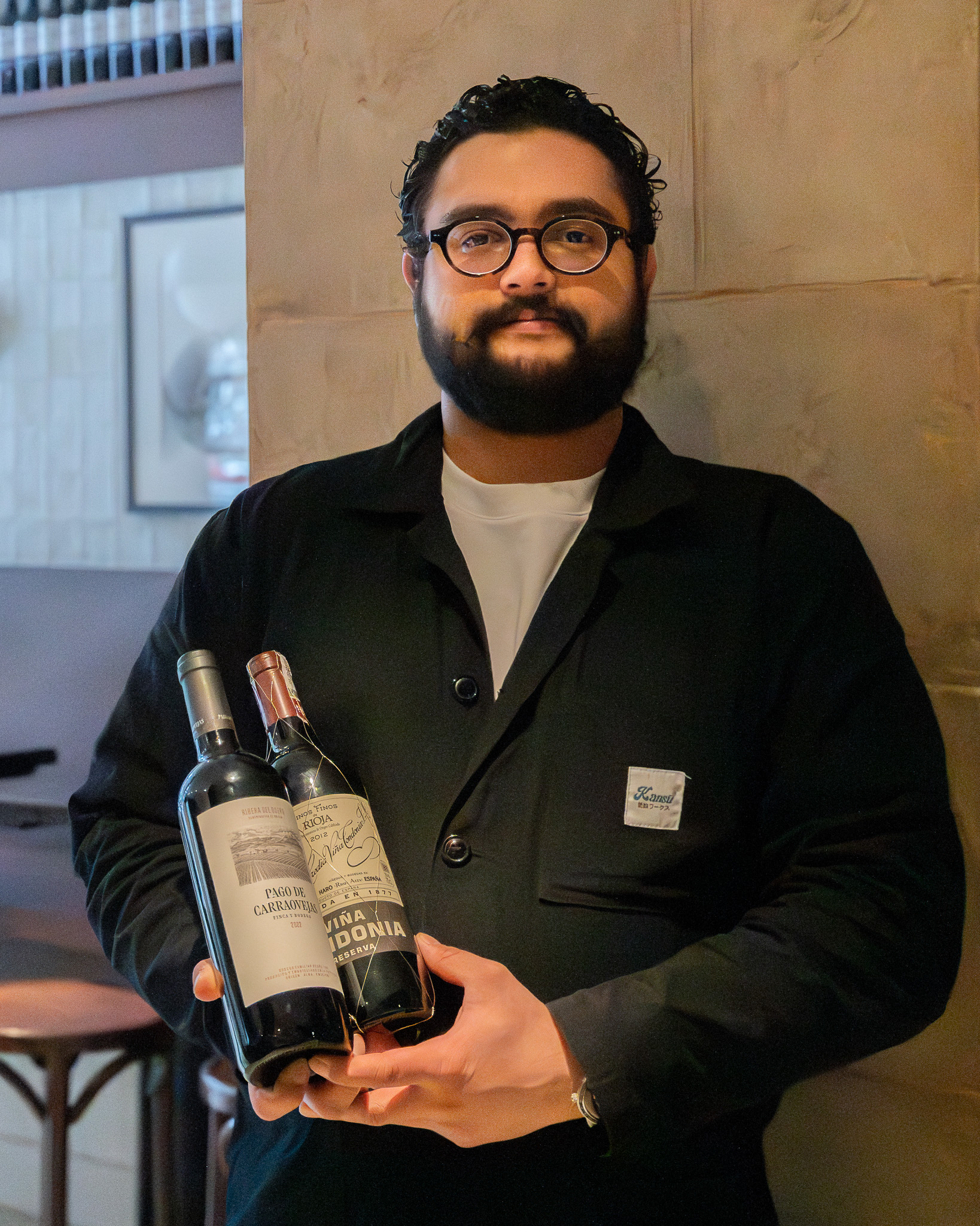 a man holding two bottles of wine