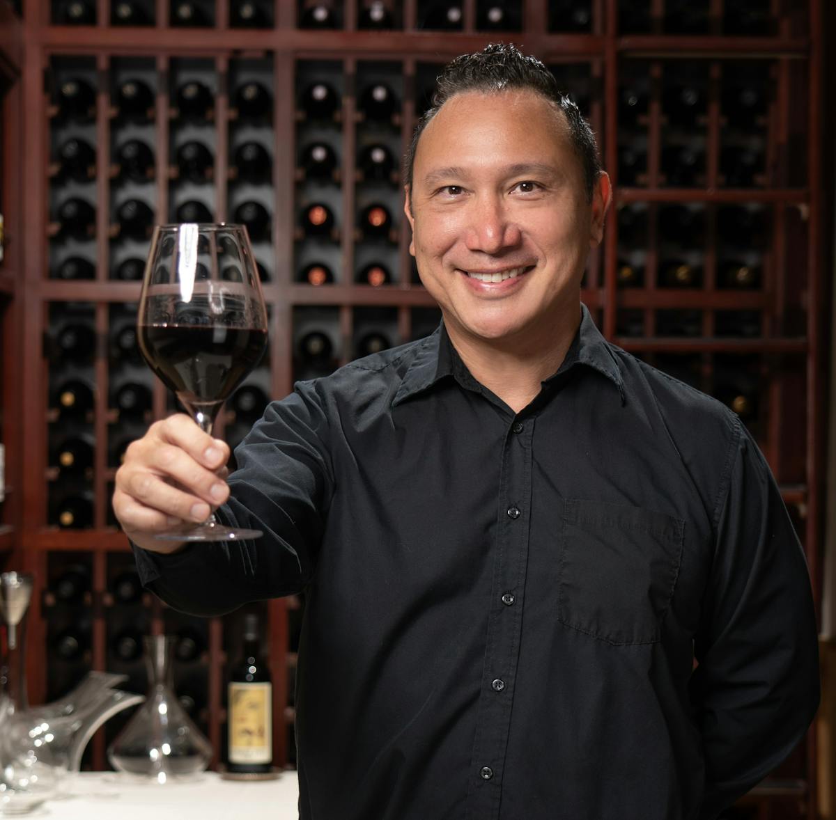 a man holding a wine glass posing for the camera