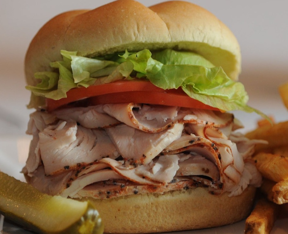 a sandwich is sitting on the side of fries