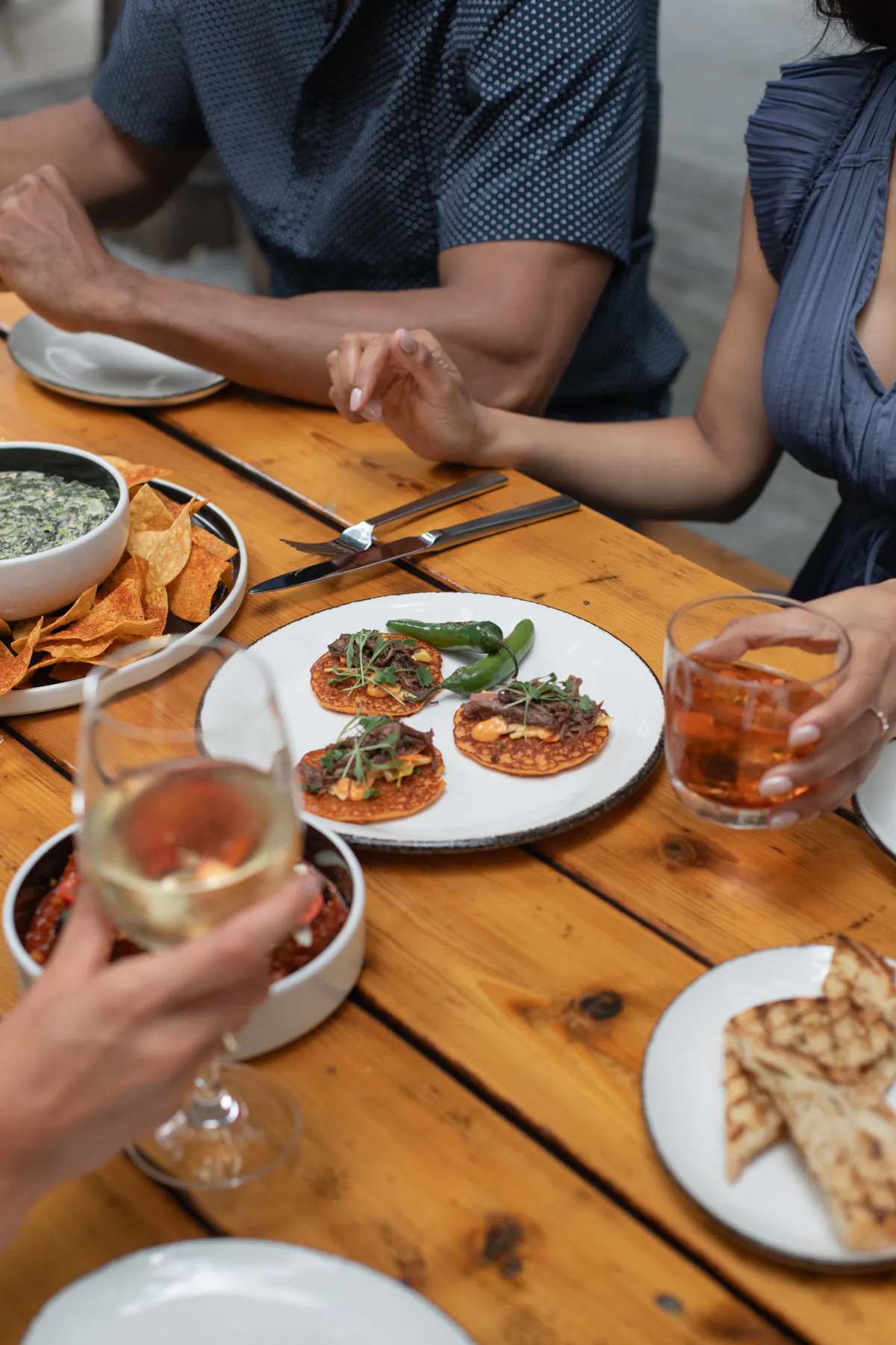 a group of people sitting at a table with food and drinks