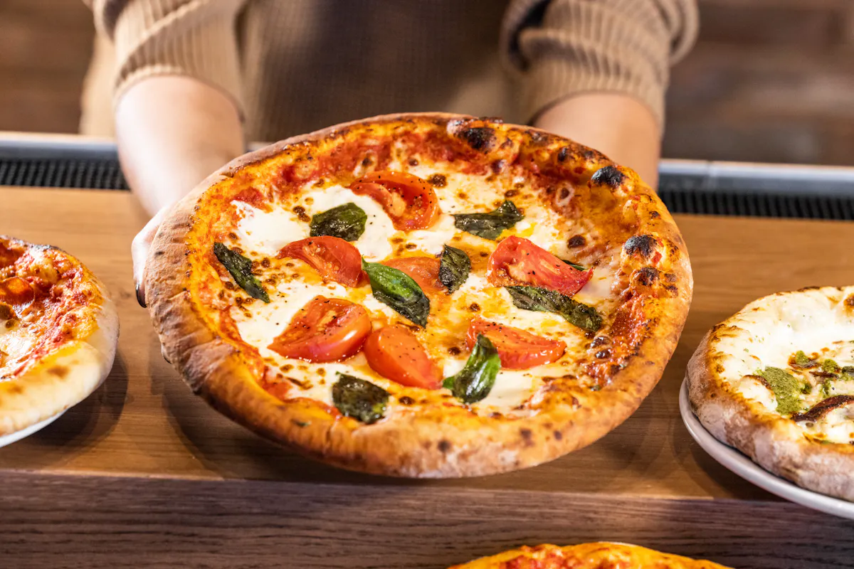 a person holding a pizza