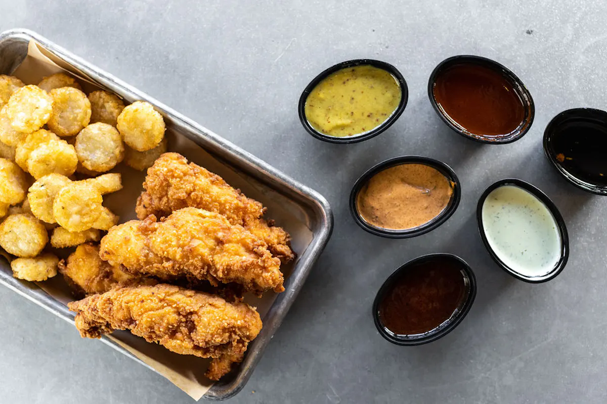 a tray of fried food with sauces