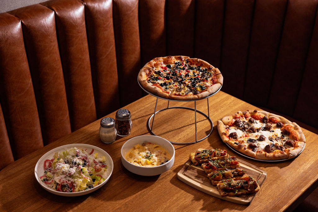 a table with pizzas and bowls of food