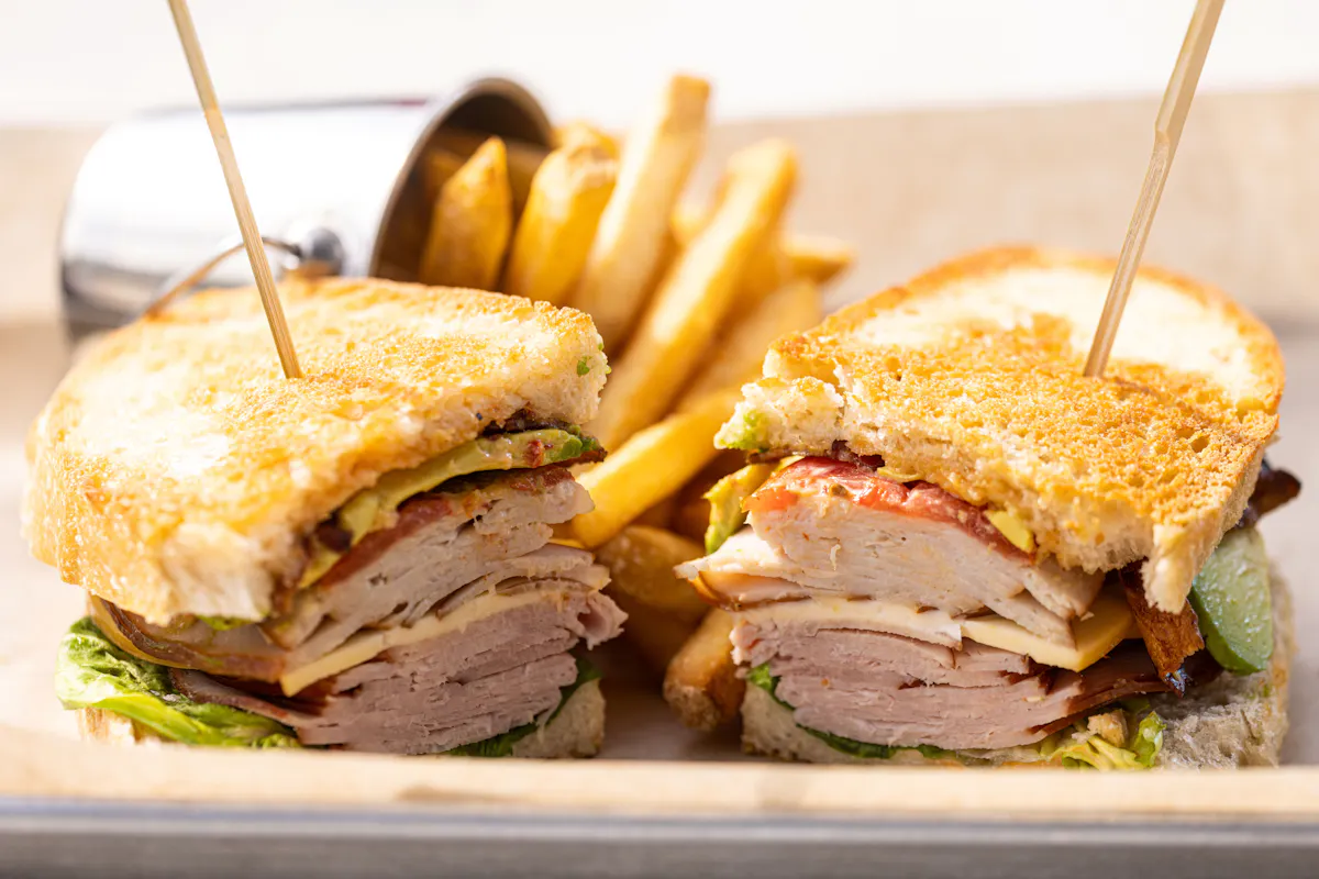 a sandwich cut in half with french fries