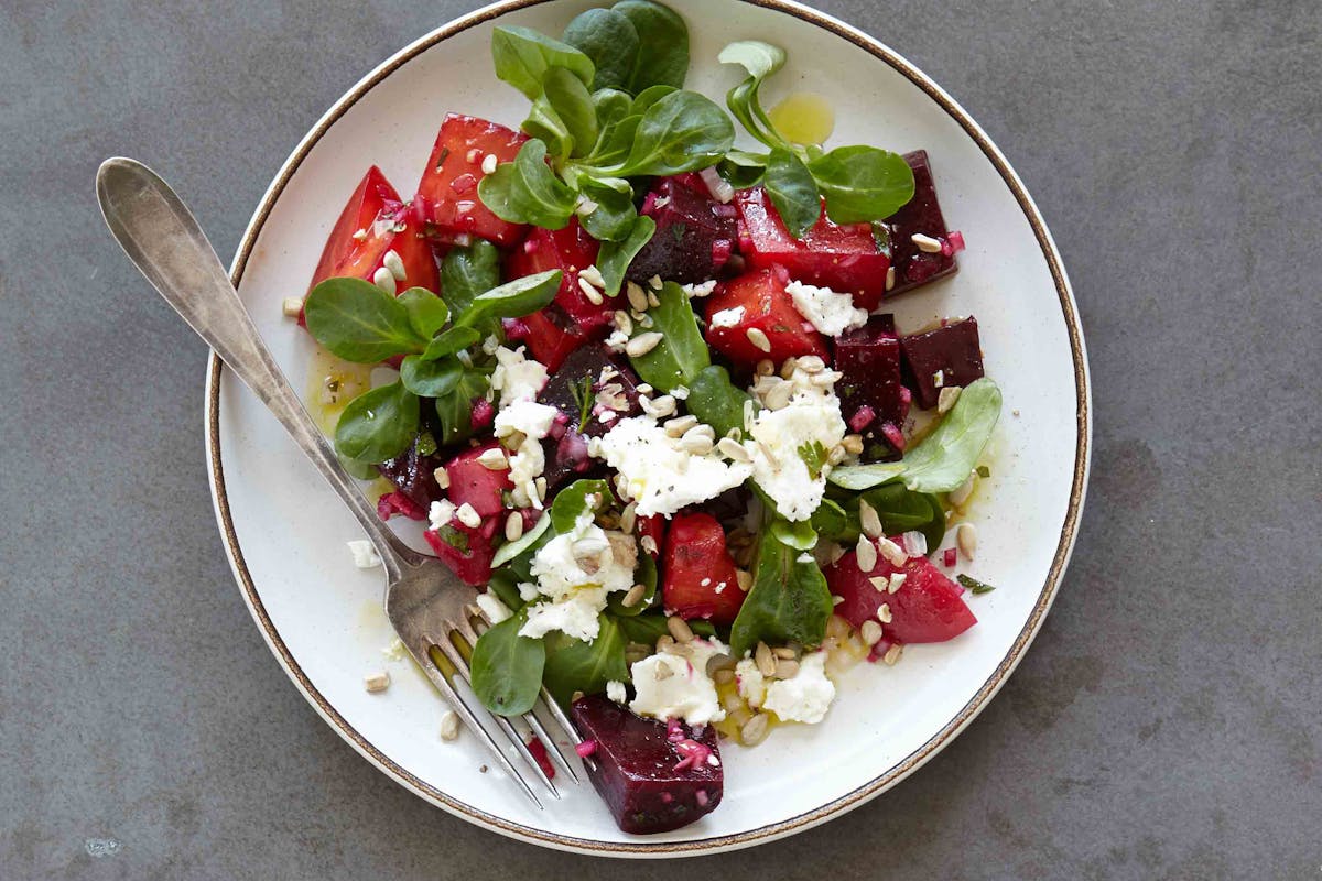 A plate of salad on the table.