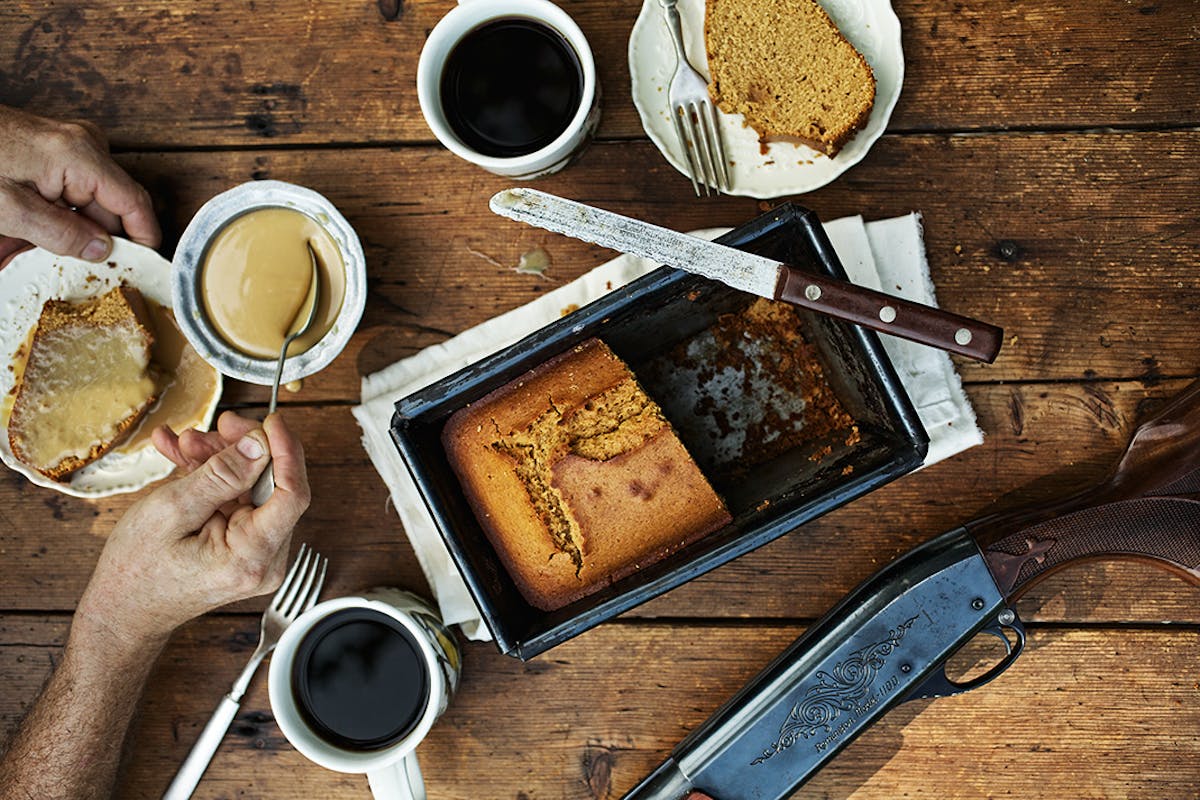 A tray of cake with hot brew and a knife