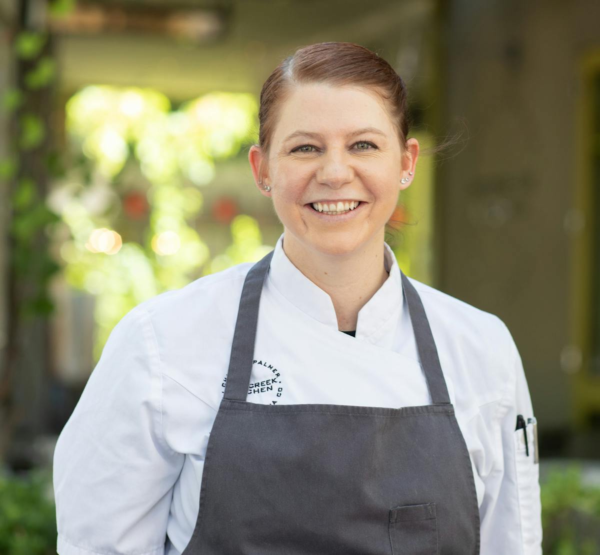 a man wearing a white shirt and smiling at the camera