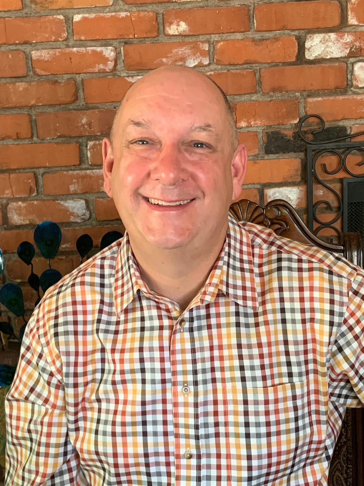 a man sitting in front of a brick building