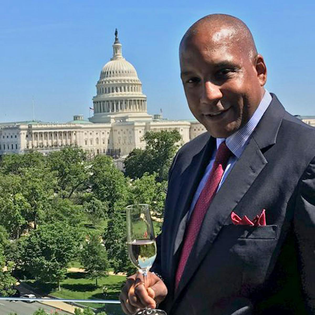 a man wearing a suit and tie standing in front of a building