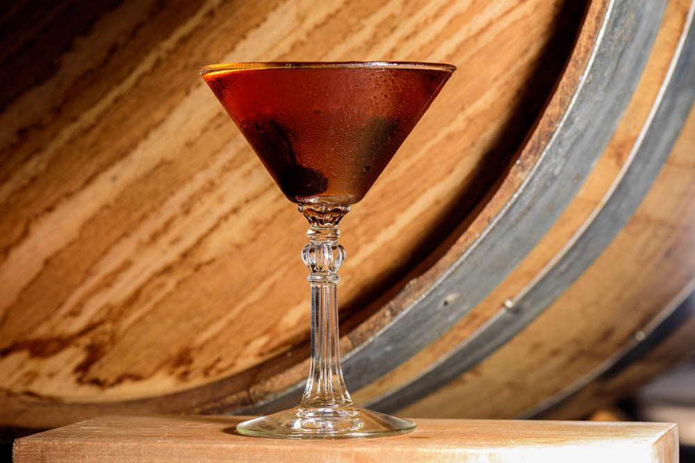 a glass of wine sitting on top of a wooden table